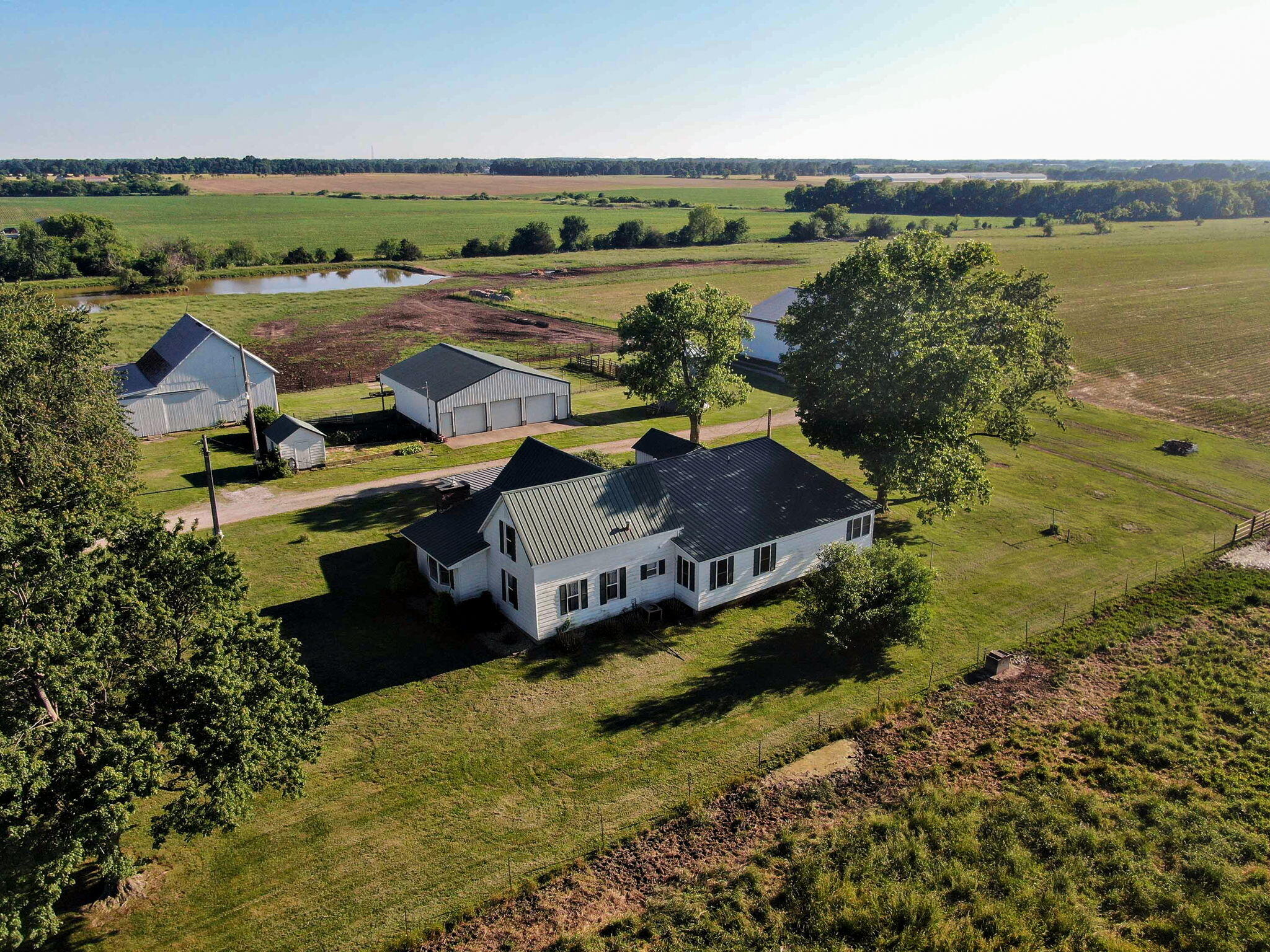 Beautiful farm house with many updates on 78 Acres.  Land is a mixture of crop and pasture with 3 acres in woods.  Outbuildings include 50X80 pole barn with 15 ft high doors, 40x32 shop with 40x12 lean-to and 48x54 barn with loft and lean-to.  2 ponds and water access to pastures.  Home has 2388 square feet on main level with 2 living rooms, formal dining room, huge primary suite with dual sinks, walk-in shower, soaking tub and large walk-in closet.  Kitchen has had updated lighting, counter tops and backsplash.  Utility room has sink and lots of built-in cabinets for extra storage.  2nd bedroom is spacious.  3 full bathrooms.  Lots of natural light. Bedrooms 3 and 4 are on 2nd floor,  and do not have heat in one of them. Home and barns also have automatic generator incase of power outages.  Property has natural gas.  This is a great farm and less than 15 minutes to Monett, Mt Vernon and I-44. Half way between Joplin and Springfield.