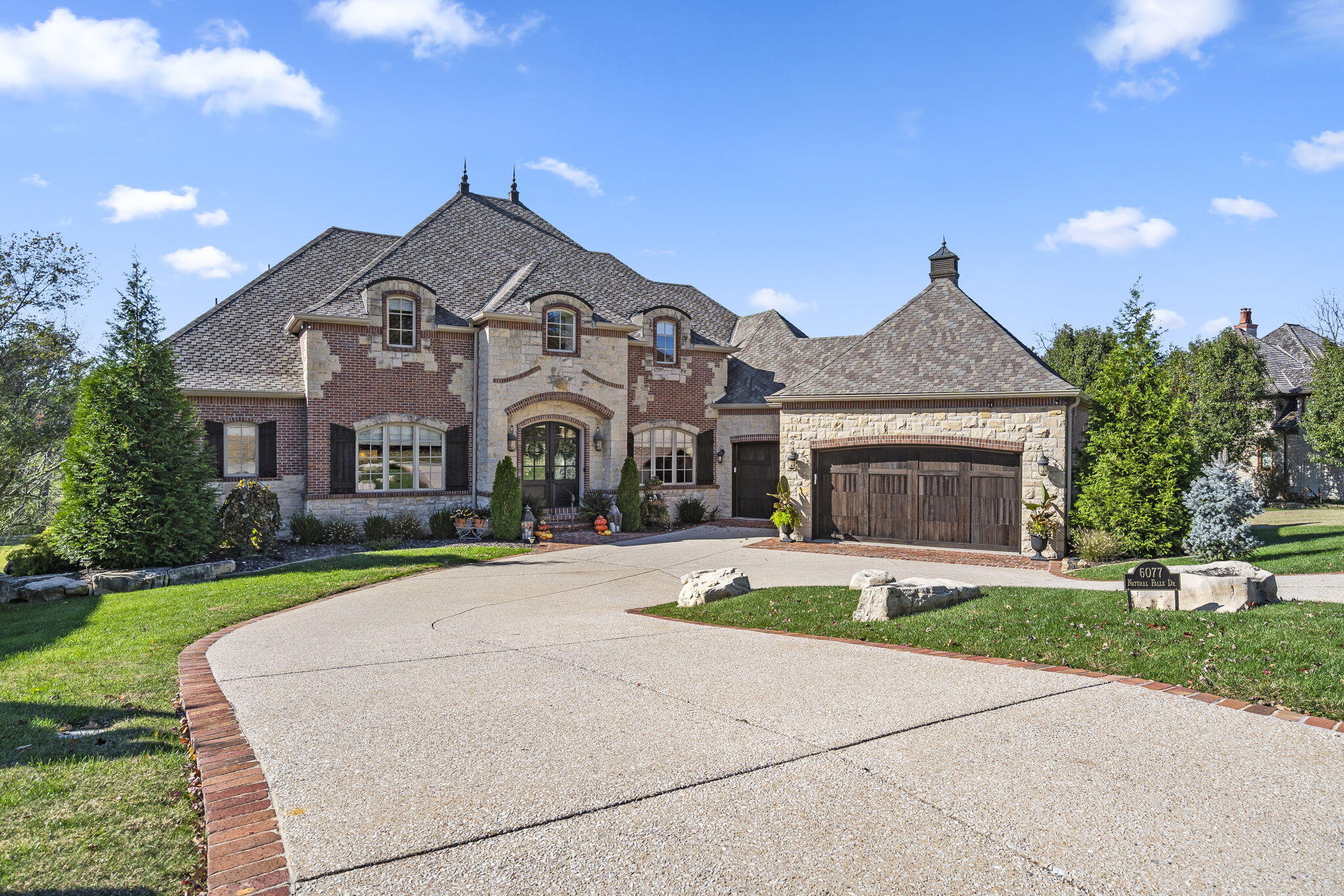 Nestled within the picturesque landscape of the Ozarks, this exceptional home offers an unparalleled opportunity to experience the epitome of luxury living. This stunning home is an oasis of elegance, situated in a prime location along the immaculate fairways of Millwood golf course, providing not only a prestigious address but a lifestyle of refinement and leisure. Step inside this majestic abode through a grand two-story entrance, featuring a sweeping staircase that sets the tone for the entire home. The formal dining room features large picturesque windows and gorgeous pillars. The formal living room features a perfect view of the course, a large cozy double sided fireplace with built in storage, high ceilings, and tons of natural light. The custom kitchen is a culinary enthusiasts dream and features plenty of storage, stainless steel appliances, bar seating, and gorgeous granite counter tops. The luxurious master suite is located on the main level and is complete with a spa-like en-suite bathroom, large walk in closet with sitting area, and panoramic windows featuring stunning views of the golf course. The main level also features an office with built in shelving and gorgeous hardwood floors. Upstairs you can find an additional living area and two large guest bedrooms that each have a private bathroom attached. The basement offers beautiful cobblestone flooring, a full bar with seating, and large living area. The beautiful brick fireplace will keep you warm during the cold Missouri winters. You can also find a full bathroom for guests and additional bedroom that is currently used as a gym. Once outside you are greeted with a large deck that offers a perfect view of the course and downstairs you can find a large patio perfect for gatherings or al fresco dining! Don't miss all this gorgeous home has to offer, schedule a showing today!