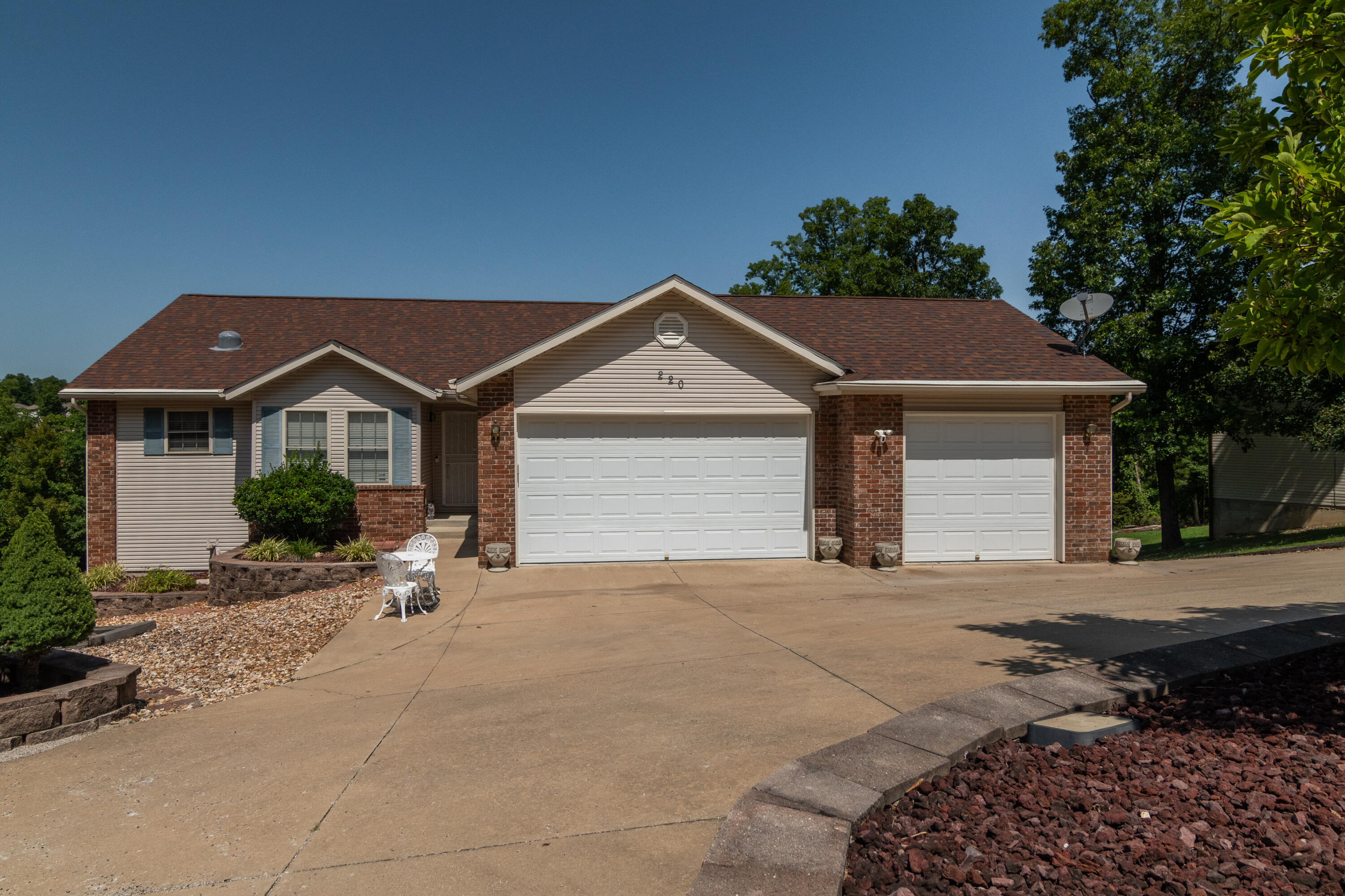 Welcome to 220 Tall Oaks Drive! This custom-built home offers plenty of space on the main level for everyone and a large lower level for entertaining, guests and hobbies. When you walk in the front door, you'll be greeted by the open living room with wood floors, vaulted ceiling, stone fireplace and a view of the Ozarks through the heated and cooled sun room. The kitchen comes fully equipped with all appliances and the dining area is large enough for family and friends. The master bedroom, master bathroom, two guest bedrooms, guest bathroom, laundry and three car garage are all on the main level. Downstairs you'll enjoy the spacious family room, fourth bedroom, full bathroom, sun room and lots of extra storage. There's even an 11'x30' shop building with paved access and electricity for the hobbyist. Horizon Hills subdivision offers a large playground, This home is located within the Branson School District and is minutes to Highway 65, Table Rock Lake, Lake Taneycomo and all the fun Branson has to offer. Whether you're looking for a vacation getaway or full-time easy living, this home has it all!
