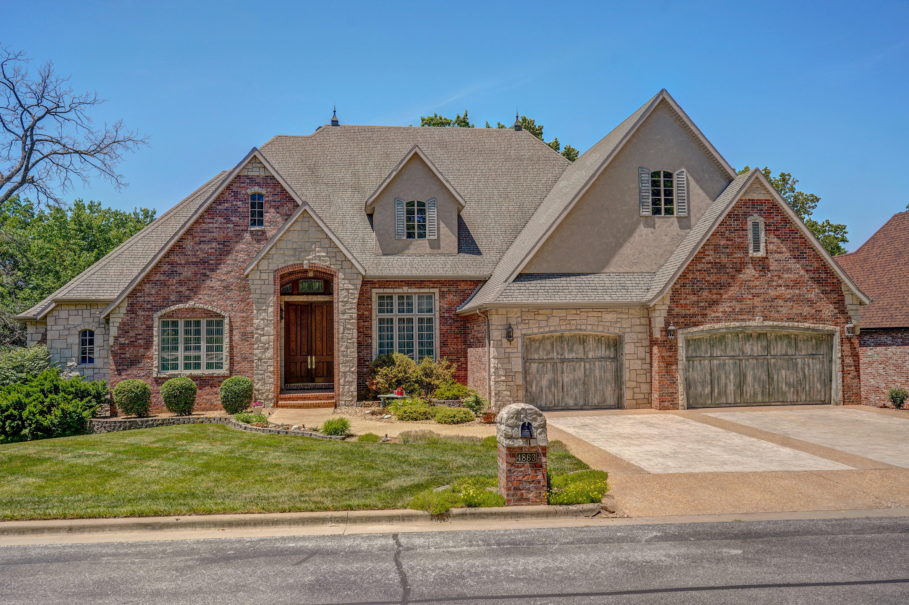 Desirable gated community. Real stone & brick exterior. 2x6 construction. Interior has antique beams & doors. Granite kitchen with hand-painted tumbled marble backsplash. 2 full kitchens, all bedrooms are large and with private full baths, 15x26 office, media room, exercise room, stamped concrete upper, covered deck, custom interior decor, beautiful front & back yard. You have to see this home to appreciate all of the amenities.