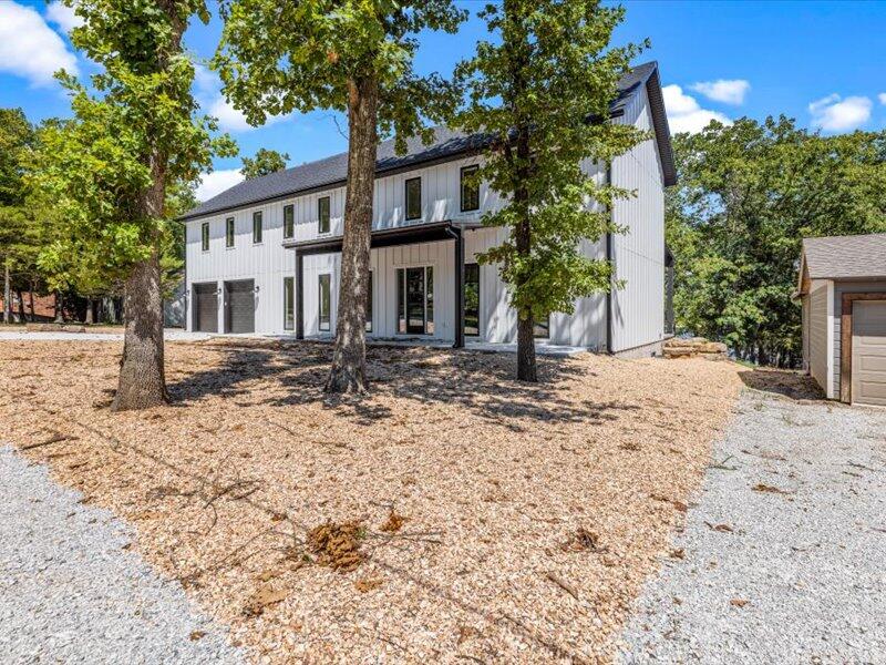 If you are wanting the most amazing lake house in the Reeds Spring area, look no further! This gorgeous 2022 built home is 4 bedrooms, 3 1/2 bathrooms and is waiting for you! From the moment you pull up you notice the vast size and modern look to this property. Inside be taken away by the open floor plan, modern color scheme and the intricate detail from floor to ceiling. The main living space features built in shelving, flood lighting and opens in the amazing kitchen where you will find and oversized island with bar seating, drop lighting, and concrete countertops. Also, the brand new appliances including the double oven and commercial cooktop will make entertaining a breeze, and the walk in pantry provides more storage than you could ask for! The laundry hall is a dream with lots of cabinets, concrete counters running along both sides and a sink for convenience. The favorite part of this home the the Master suite! Find your comfort and peace in this grand bedroom and private bathroom featuring his and hers sinks, double shower head walk-in tile shower, soaking tub, water closet and large walk-in closet.enjoy the beautiful views of the lake from the covered back porch or enjoy walking down to your private dock and spend quality time with friends and family living the lake life! Photos and words do not do this home justice. Come by for a showing and see it for yourself today!
