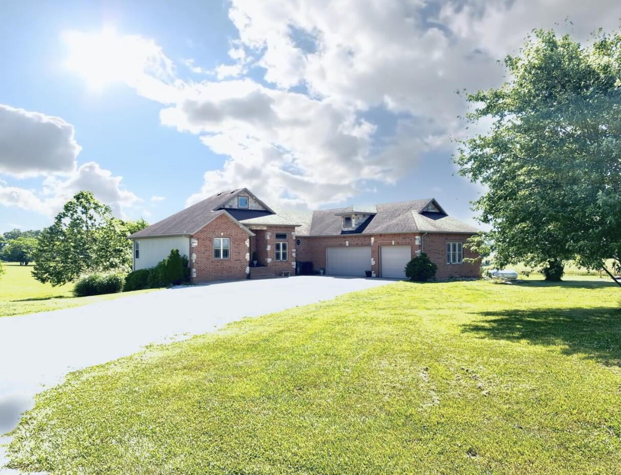 Beautiful walkout basement home in Ozark School District! Situated on 6.13 acres m/l is this stylish brick front home. Beautiful kitchen with snack bar and stainless appliances! Tall geat room with see thru fireplace! Large main floor owners suite w/ oversized en suite. Huge downstairs entertaining area with wet bar. John Deere room perfect for extras. Detached shop is 30x40! Duel Fuel Heat pump is only 2 years old!