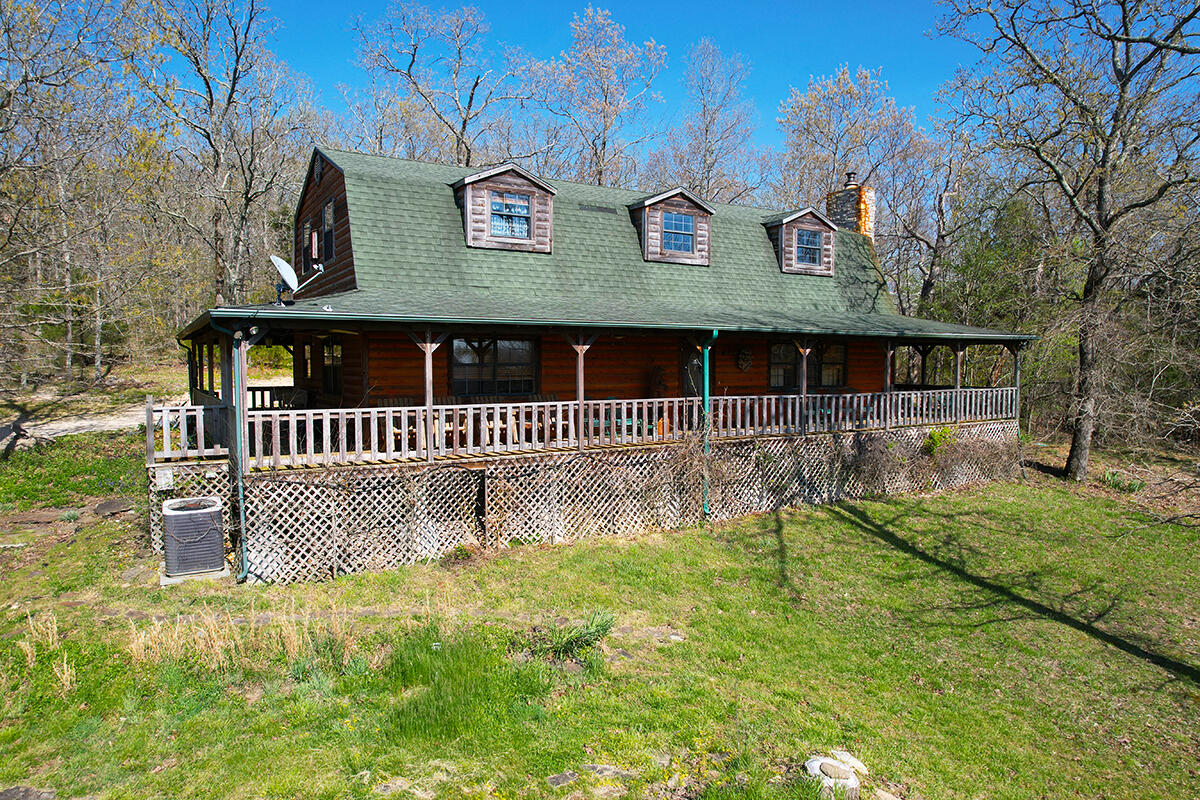 Luxury Home on 121 Acres -- Prime hunting and outdoor recreation property - Come home to this remote haven of natural beauty spread out over 121 acres at the foot of the majestic Ozark Mountains. Whether as your primary residence or private weekend retreat, you'll have front-row seats to the best nature has to offer, from the panoramic views of rolling hills to afternoons fishing in the spring-fed lakes to rejuvenating strolls through specular trees. Plus, with its location less than 30 min. from Hwy 65, you can make it home from work in time to end every day enjoying breathtaking sunsets from the comfort of your wraparound porch. The one-of-a-kind, 2-story house was intentionally designed to blend into its incredible setting. The open floor plan, wide-plank wood flooring, vaulted ceilings with wood beams as well as custom extras like its sealed-wood countertops and stone accents create a warm, relaxing lodge-like setting. Picture yourself gathering with family and friends in front of the stone fireplace, shooting a game of pool on the table that stays with the home or enjoying a home-cooked meal at the kitchen island bar. The main bedroom suite with a full bath is conveniently located on the main floor as is the laundry room and a half bath. Upstairs, kids and guests can lounge in the loft-style living room that overlooks the main floor, and the 2 bedrooms and full bath add extra privacy as well. Much of the perfectly placed furniture stays with the home, including log bunk beds that will make this every kid's favorite sleepover destination! This incredible property, which borders a 500+/- acre tract of Mark Twain National Forest on 2 sides, offers hobbyists and outdoor enthusiasts endless options year-round. A detached workshop comes with electricity as well as inspiring views of the lake. Enjoy extensive trails by foot or with ATVs, prime hunting opportunities from several fixed tree stands and the stocked 1.5-acre lake. The metal outbuilding offers extra storage.