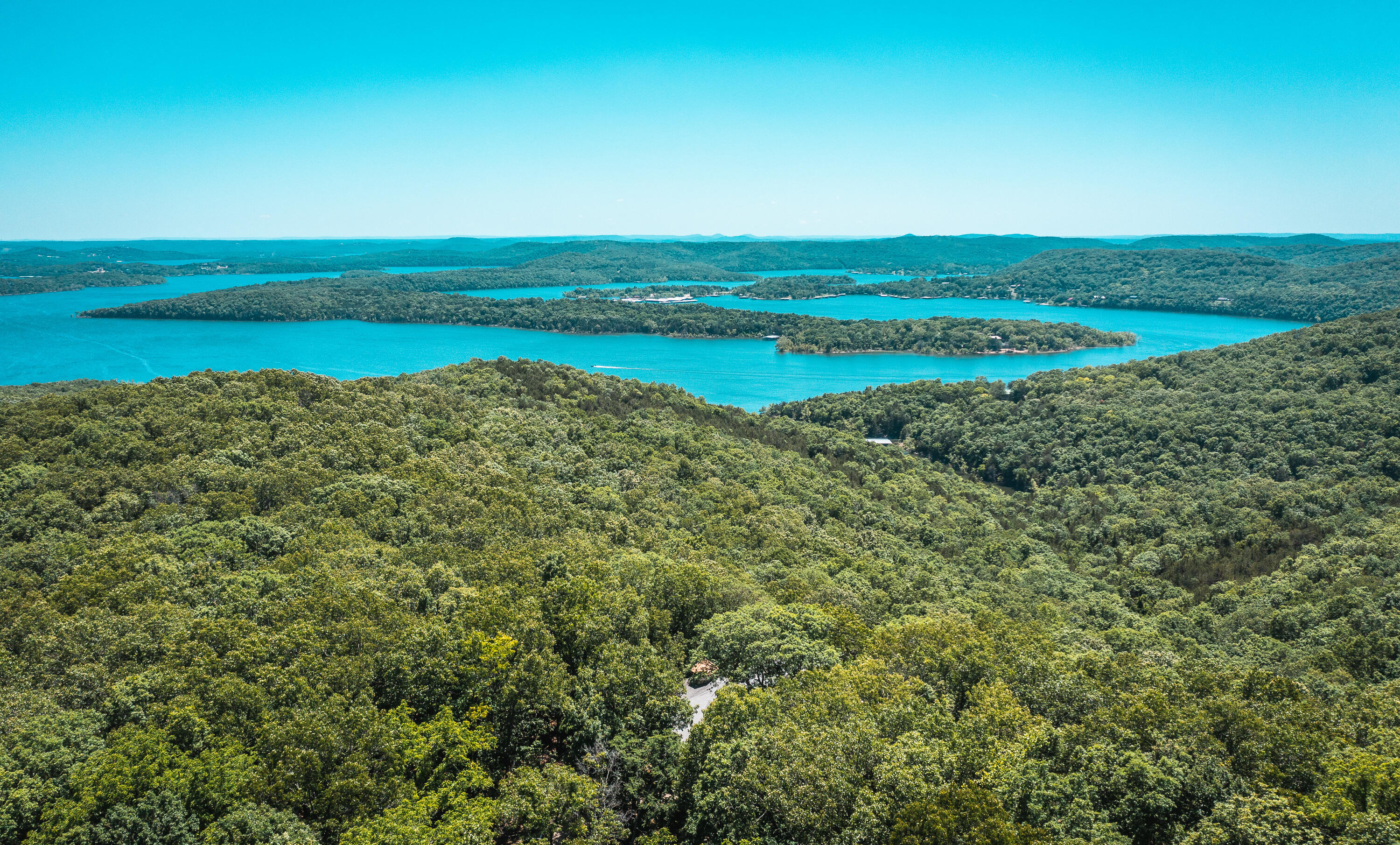 Come take a look at this beautiful custom lakeview home with 20+/- acres that borders 80 acres of Mark Twain National Forest, lots of room to play. This spectacular home boasts so many custom details, it's impossible to list them all. This 3,897 square foot home features 4 bedrooms, 4 baths, 2 car attached garage- sprinkler system- Greenhouse on the giant two story deck - Geothermal Ground source heat pump- backup generator- rustic den with custom hardwood floors and bar- theater room - central vacuum system- custom floors have been featured in hardwood floor magazine. On the exterior of the home, you have a 25x45 metal barn to store your boat and ATVs and a 20x25 metal shed. The nearest boat ramp is just a few miles down the road, so you can be on the lake in no time. Additional 6+/- acres available for $50,000.