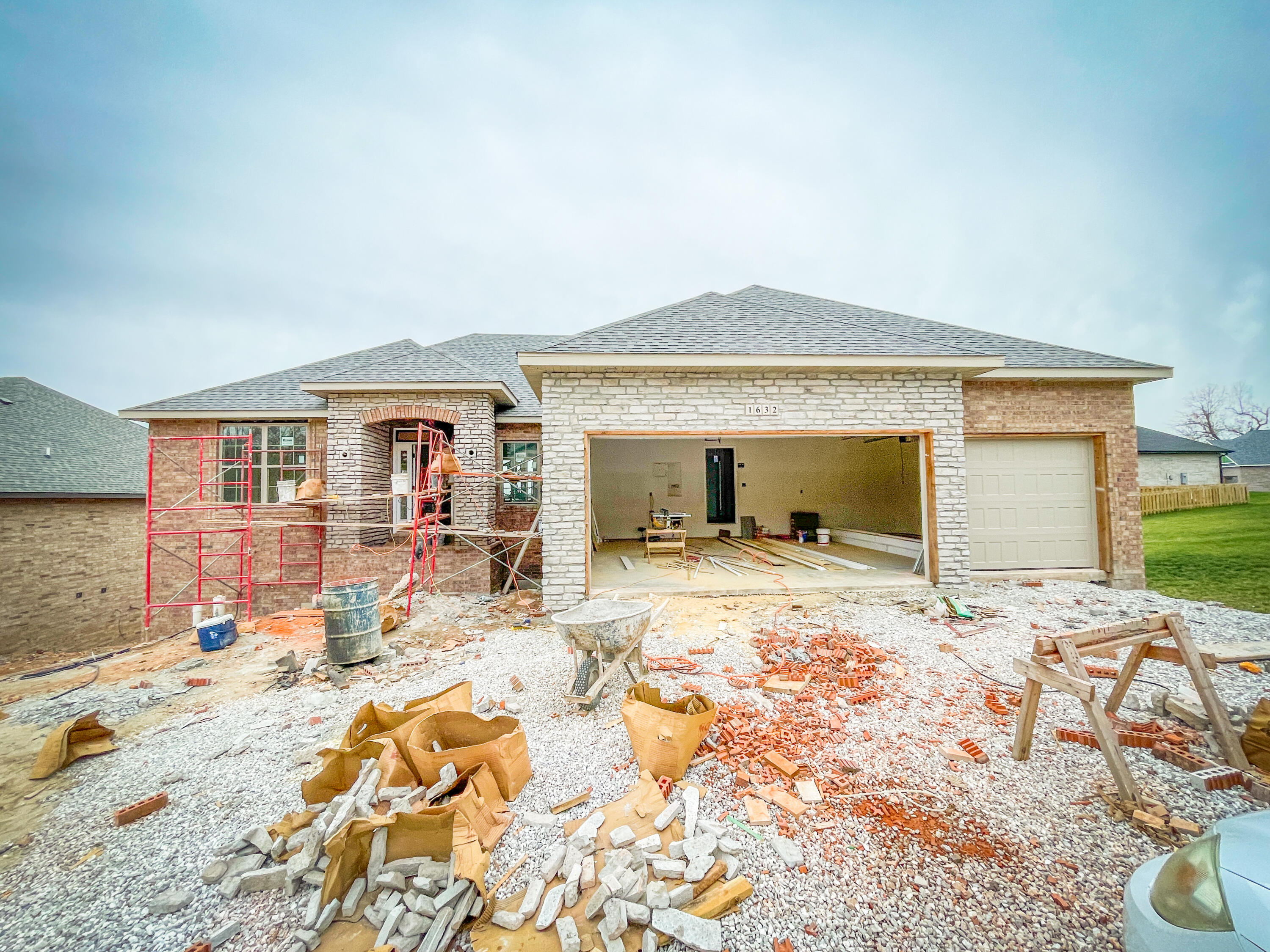 Brand new home in Beautiful Gated Lions Gate! Backs up to trees! 5 BR , 3 1/2 baths, walkout basement! It can be a 30-day closing no problem. All brick/stone exterior with a two tier landings out the back. The interior flooring is engineered wood, Granite countertops, beautiful trim and doors, gorgeous all wood cabinetry with soft close doors and drawers and all hidden hinges.  There are 2 laundry rooms one on each level. There is John Deere room in the basement. This home Apprx 4000 Sq ft. This home will have all wooden shelving in bedrooms and the pantry. 3 BRs on main level with 2 additional in basement. Multiple living areas including family room in the basement. The appliances are Stainless and include gas range, dishwasher, microwave & offers a walk-in pantry with wooden shelves in kitchen. The front and side yards will be sod & Irrigation, the back will be seed and straw. This builder insulates the garage walls, garage doors and in the attic above the garage and He also vents his hood above of the stove to the outside. Very few builders do either of these items his are standard. The garage door openers are smart openers so you will never worry about your garage door being open after leaving for a trip. You will want to come and look at this home and claim it before it is gone.