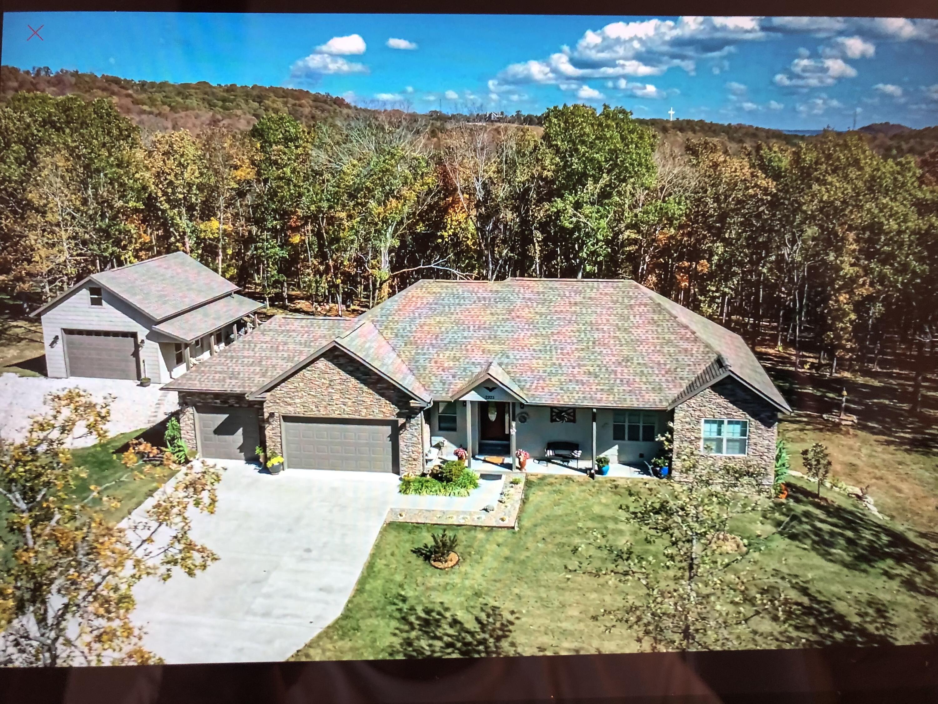 Welcome to your 5 acre property that is perfectly nestled inside Emory Creek Ranchwith beautiful views of the rolling hills and just minutes from Table Rock Lake,Branson Landing and shopping. You can stroll down to your own private creeklocated on this estate. This one-story, walk out home features a large, open floorplan upstairs and down, both with custom stone gas fireplaces that make it perfectfor family gatherings on both floors. Beautiful hard wood floors upstairs in living,kitchen, dining and master suite. The large master suite located on the main floorhas a coffered ceiling, a custom stone gas fireplace, 2 walk-in closets and jetted tub.There are 2 additional bedrooms also located on the main floor with a beautiful fullbath between them. The kitchen features a big island, including a Ruvati stainlessworkstation sink, Moen faucet, custom pantry with pull out shelving, new KitchenAiddual fuel gas range, hood and refrigerator with custom granite countertops. Thiskitchen is a chef's dream. There is a full laundry room upstairs with customcabinetry, stainless wash sink and granite countertops. The lower level is acomplete 2 nd living area, perfect for mother-in-law or two families. The full kitchenthat includes high end cabinetry, granite countertops and KitchenAid appliances,with walk-in pantry and a laundry room that includes a new GE stackablewasher/dryer and cabinet with stainless wash sink. There are also 2 large bedrooms,2 full bathrooms, a large living area/game room, den/office and finished storm/saferoom that can be used for an unconventional 3 rd bedroom downstairs. New WoodTrend Porcelain tile floors. New ceiling fans and LED lighting throughout. A MUSTSEE! An oversized deck off the great room and a patio on the lower level gives yougreat outdoor space and lots of privacy to enjoy your morning coffee or evening BBQ.A 3-car attached garage along with the 2-car 24x30 detached garage/workshop. Aparadise for