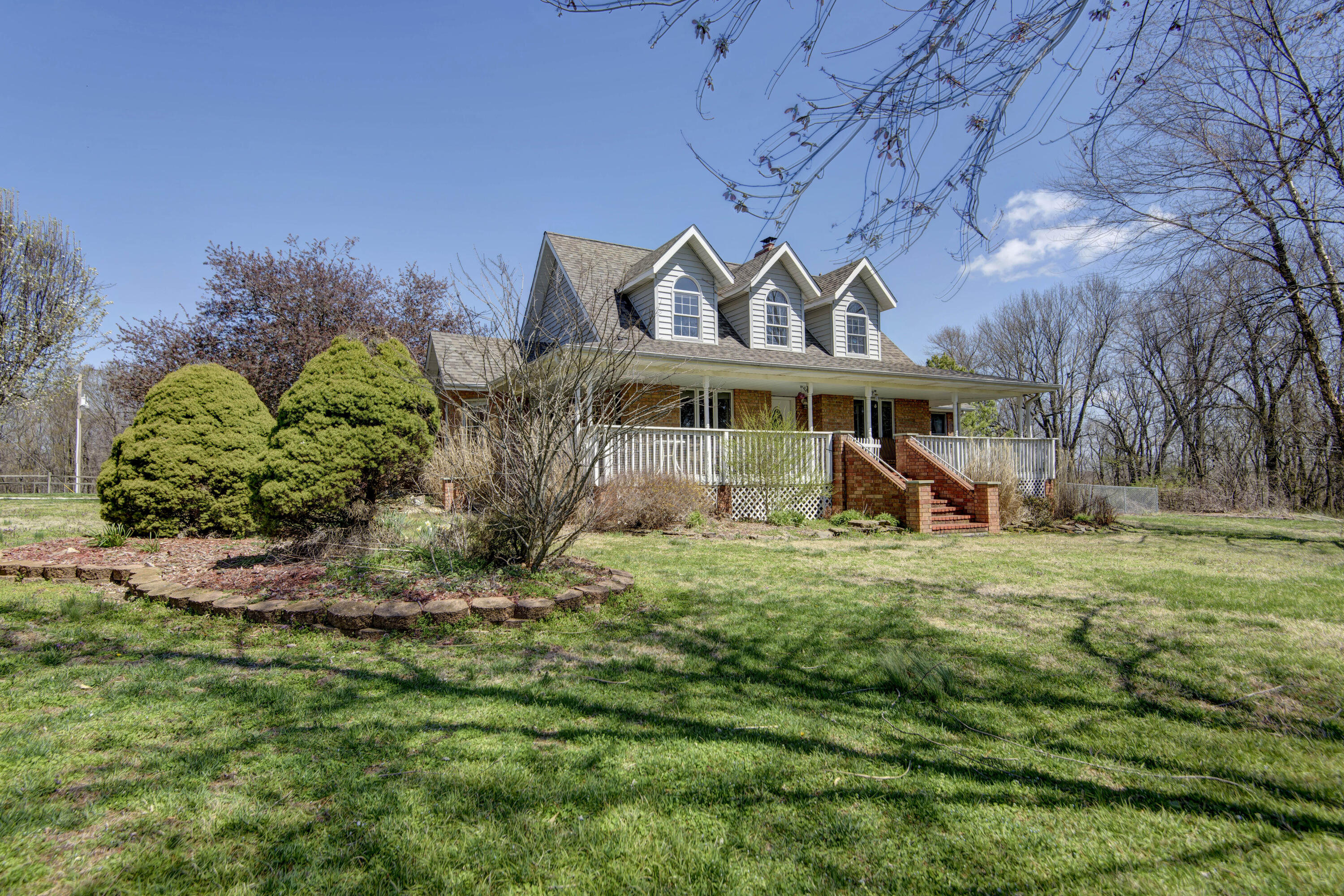 Welcome to 5560 North Brynwood Lane, a beautiful South facing Cape Cod with nearly 5 acres on a dead end lane. Wildlife and serenity abounds out here. Home features a brand new roof, newer siding and a wonderful wrap-around front porch overlooking the large front yard. Inside you'll find hardwood flooring throughout both levels. The main level includes formal dining room, living room with wood burning fireplace, master suite with dual vanity, walk-in shower and walk-in closet, an office or 4th bedroom, and half-bath off the laundry. The kitchen features newer KitchenAid appliances, eat-in breakfast nook and custom twin pantry cabinets.  Upstairs is a 2nd living space/4th bedroom as well as 2 bedrooms with Jack-n-Jill bath. Out back, you'll find a log-sided bunk house/guest cabin with bunk beds, wood stove and portable air conditioner, great for the kids, a man-cave or she-shed getaway!  On top of all this, the barn/shop, with plenty of storage both up and down, is the icing on the cake.