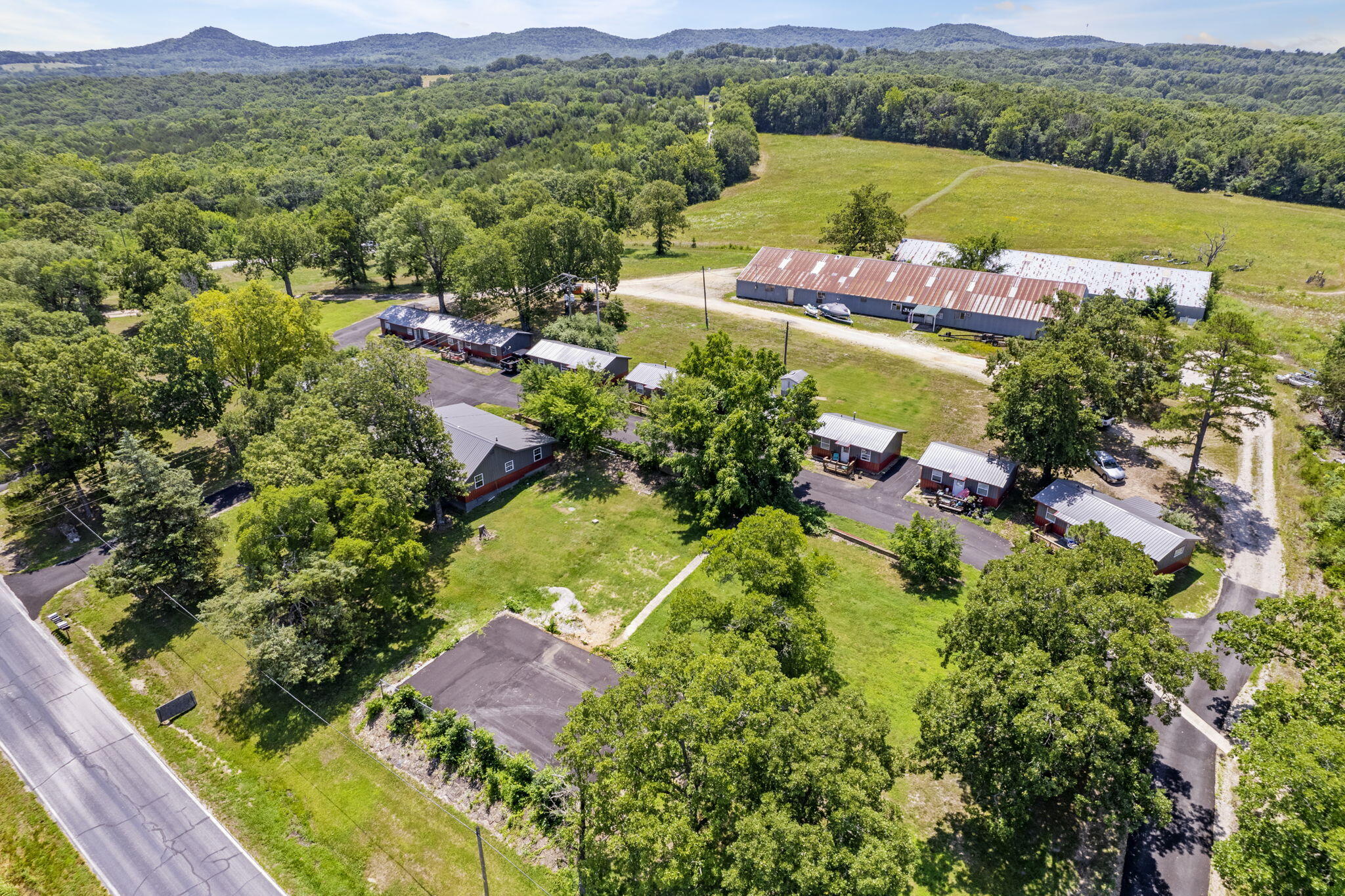 What an incredible opportunity in the rapidly growing area of Shell Knob!  So many choices for various possibilities occupying approximately 11 1/2 acres. There are currently 8 cabins, a single family residence (3 bedroom/2 bath home with detached garage), 2 - 60 x 120 storage buildings (multi-purpose)  with all sitting on approximately 11 1/2 acres for expansion of whatever your dreams are.  Prime location as it is right off Highway 39 just south of Shell Knob, 3 minutes to Table Rock Lake, King's River Marina, short distance to Branson, Eureka Springs, golf courses and so much more!  Let your entrepreneurial spirit shine!