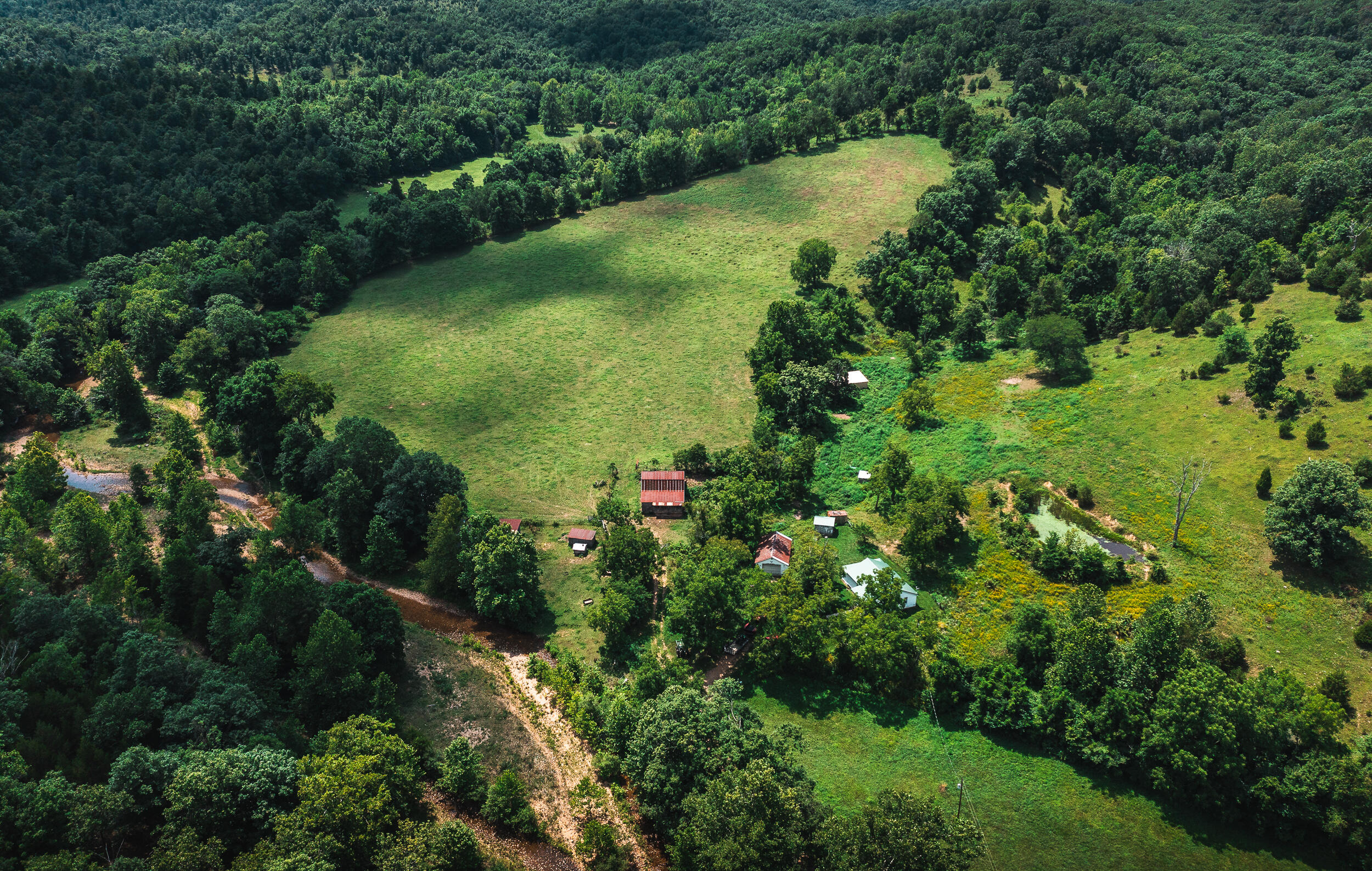 Rolling pastures, year round live water, and unparalleled beauty make 270+/- acre Chandler Farm on Crooked Creek a dream come true. Graced with years of dedicated stewardship, this property has been a working cattle farm for over 60 years, hosting up to 80+ head of cattle at a time, with still plenty of hay to put up for winter. Nearly 2 miles of spring fed Crooked Creek winds through numerous cross fenced pastures from one end of the farm to the other, allowing for rotational pasture grazing. An abundance of well established roads and trails make checking and moving cattle a piece of cake. Multiple outbuildings as well as a quaint 3 bedroom farmhouse on the hillside await all of your needs. This turn-key farm features everything you need to hit the ground running, and as we all know, in a world full of uncertainty, there are few things that we can be sure of, but one is that land is ALWAYS a good investment.