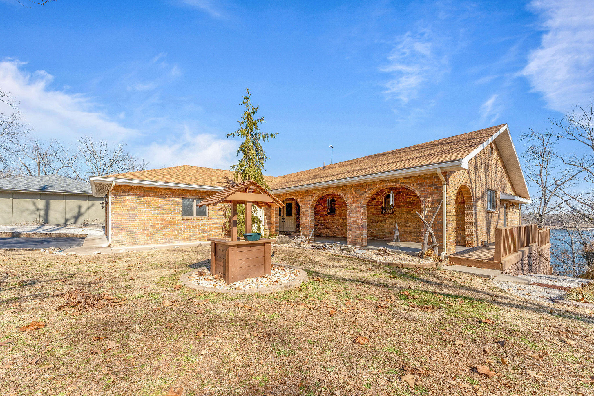 Lakefront with panoramic views!  This 4 bed, 2.5 bath home is the complete lake package!  Upstairs you will enter into a covered, arched front porch, into an extra large foyer and see a step down living and dining room ,with a shared see thru fireplace,  remodeled kitchen with granite counters, boasting newer appliances and a large pantry. Off the back of the home you will find an extra large covered porch/deck area with wide open lake views in every direction.  In addition on the main level you have a large primary ensuite, a half bath and a guest bedroom.  Downstairs you will find an additional step down den with gas fireplace, game area (perfect for card table, etc.) rec room (currently has pool table that may remain or could be bedroom and a large guest room with two walk in closets. A guest bath ,a large utility room with storage area (safe room) completes the walk-out level.  Large covered patio off the downstairs leads to path to sitting area and lake.  Quality, space, and extraordinary storage are special features of this home.  Dock is across from the driveway in 2 minutes, slip is one of the best on the dock! 11x28 slip is available for extra $$.