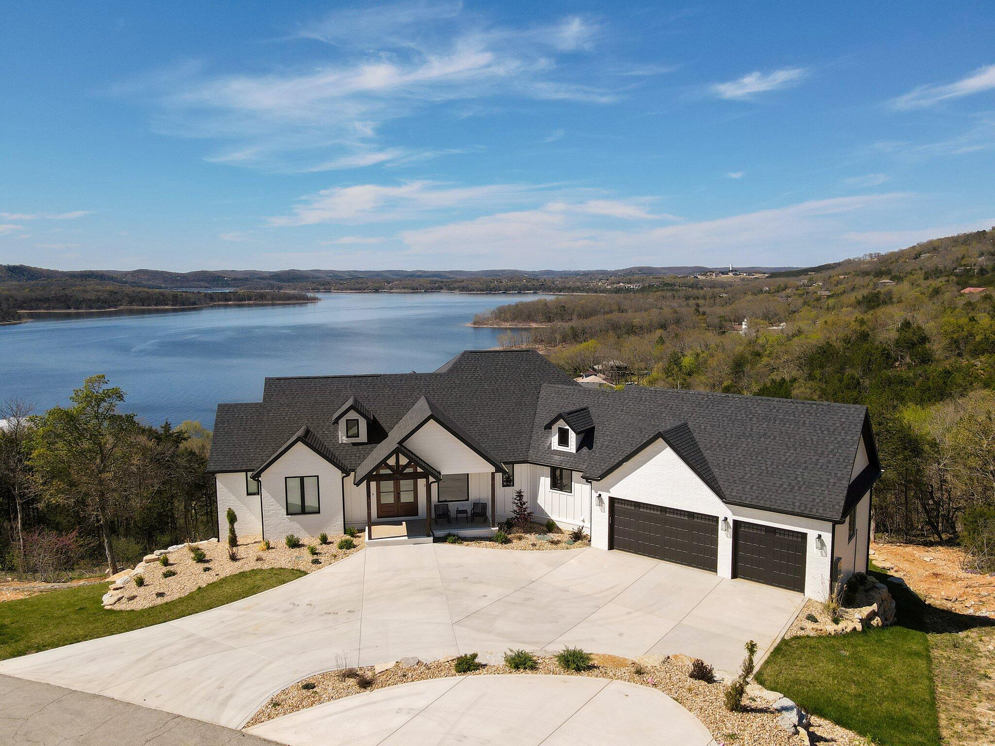 Rare opportunity in Kimberling City. Views! Views! Views! Escape to tranquility in this exclusive gated community nestled in the heart of Kimberling City, where every room (including the master shower!) offers stunning panoramic views of Table Rock Lake. Whether you seek a weekend getaway or year-round sanctuary, this home promises the ultimate lakeside lifestyle. Through the grand double front doors, you will enter into a modern haven, where the interior seamlessly blends cozy elements with contemporary flair, ensuring comfort and sophistication at every turn. With each detail thoroughly planned, the quality of this home will exceed your expectations yet confidently give you the functionality and design you have come to expect in an Oller home. The chef's kitchen boasts top-of-the-line commercial grade THOR appliances, quartz countertops, custom cabinets with under-cabinet lighting, catering to culinary enthusiasts and providing convenience and storage.  The oversize Andersen windows and 12-ft sliding doors bring you the views you have always dreamed of without sacrificing efficiency.  The split floor plan offers 3 bedrooms along with 2.5 baths on the main floor along with a spacious mudroom which includes bench and lockers for optimal organization. Also on the main floor, the laundry room with its custom racks and sink overlooking the front of the property allows for maximum functionality.  Retreat to the master suite, where serenity meets luxury, with plenty of space and privacy. Wake up to unparalleled views and indulge in the master shower with captivating lake vistas--a true oasis of relaxation. Downstairs, entertainment awaits where open spaces, a wet bar, and mini fridge sit ready for use.  All in all, with features like spray foam insulation, Andersen windows, whole home media system, 930 sq ft of outdoor living space, and views 2nd to none, this home is set up to create unforgettable memories with family and friends. (Boat Slip Available)