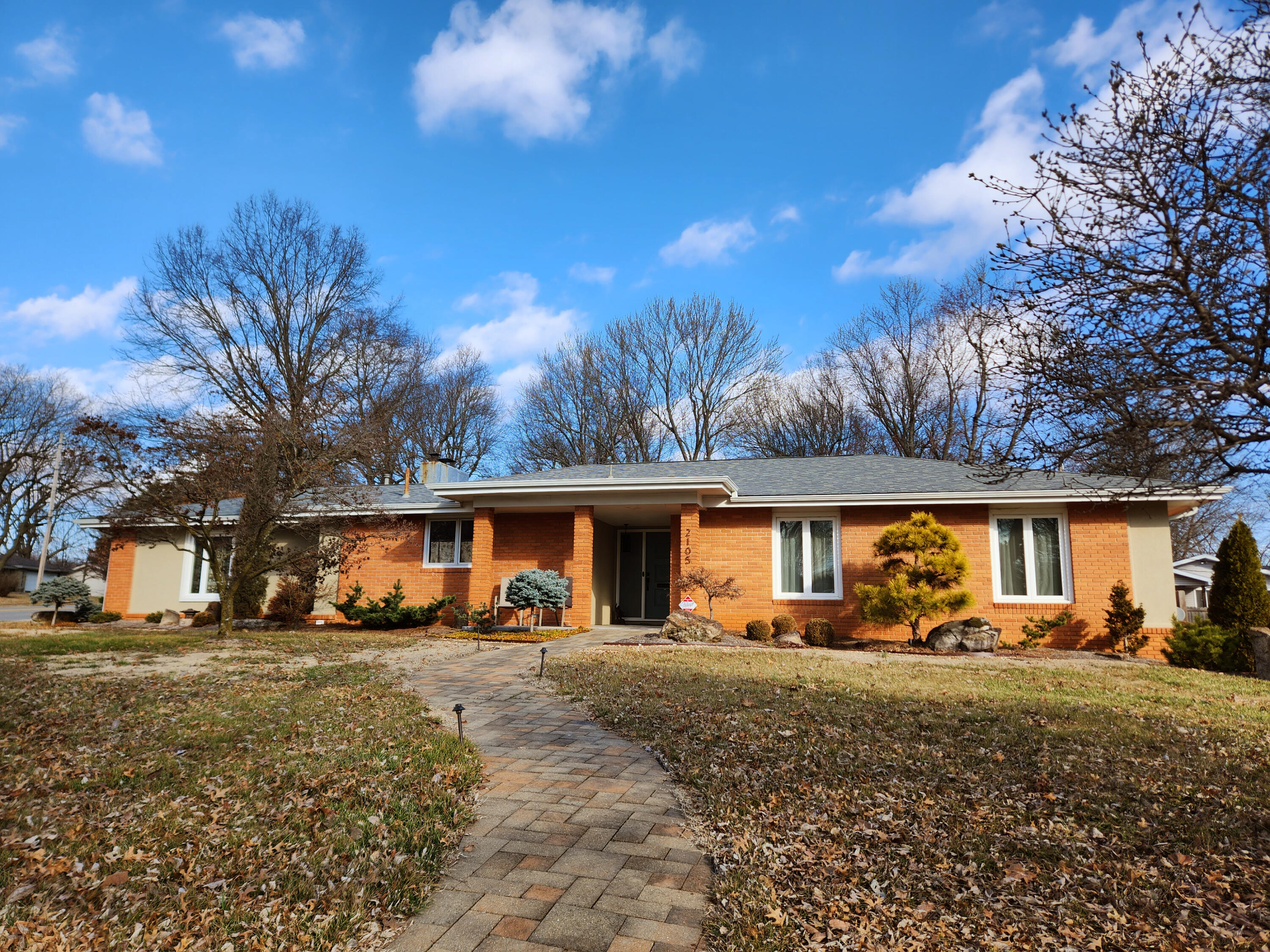 Cozy and comfortable, yet striking and tasteful, this well-loved, substantially updated one-level brick home needs a new owner! This gem sits on an oversized, beautifully landscaped corner lot in Southeast Springfield in an excellent school district. There is over 2,700 square feet spread over four distinct living areas. There are updated custom finishes and upgrades throughout, including a newish 50-year shingle roof, newer guttering, thermopane windows, a garage door installed in 2021, and a high-efficiency HVAC system only 6 years old. The water softener and on-demand water heater, like most features, were installed or updated in 2018. Solar tubes and solar-powered attic fan were recently installed.You'll be charmed by the trendy terrazzo hallway and real hardwood floors throughout.  The kitchen features plentiful cabinets, appliance garage, extensive granite counters, tile backsplash, and tile flooring. Some high-end appliances will stay with the home.The full guest bathroom has hex mosaic tile and built-in storage. Completely renovated en suite bathroom features a new double sink vanity, large walk-in shower, tile flooring, linen closet, and state-of-the-art bidet toilet. The primary bedroom has 2 walk-in closets, extensive built-in custom storage, and a unique feature -- sliding doors giving access to a large all-season room. This provides year-round livable space with a view of the fenced-in backyard thanks to screened windows throughout, a highly efficient heater-cooler unit and attractive ceiling fan lights. An open plan formal living and dining room greet you as you enter.  Adjacent to the kitchen are a half bath/laundry area and a family room with pocket doors that allow it to be closed off for cozy evenings in front of the stunning stacked stone fireplace with a remote-controlled gas log set. But that's not all!....