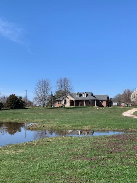 Lovely custom built all brick (with stone accent) ranch style home on 3-acre country setting parcel.  Eat-in kitchen boasts of hickory cabinets, ceramic cooktop, Corian counters, custom design tile floor, and updated refrigerator and under-counter oven.  Living room has propane fireplace, and dining area has tray ceiling with beautiful light fixture.  Bay windows galore.  Solid oak 6-panel interior doors. Main bedroom and adjoining bathroom are very spacious.  Double vanity.  Heated floor in front of jetted garden tub is a special bonus!  New roof in 2017.  New furnace in 2016.  Garden shed is in backyard.  37x40 pole building has a cute covered porch and an overhead door on each end.  Interior has a partial concrete floor and has been used to stable horses.  Four horse stalls are negotiable.  Paddock is pipe fenced and includes loafing shed. This building could make a great workshop. East/west property line has 4-strand barbed wire.  Pond in front of the home is strictly a 'wet weather' pond with NO spring.  This is a shared-well property with appropriate Agreement on file.  A portion of the driveway is under a Joint Driveway Agreement also on file.  Refrigerator, washer/dryer stay. Negotiable flooring allowance.