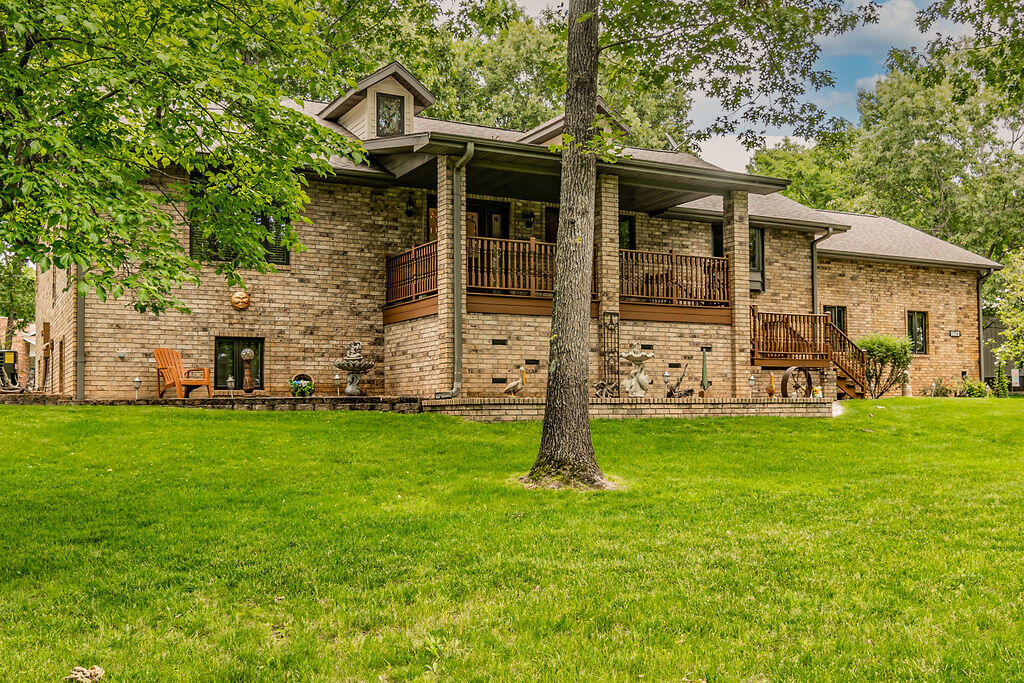 The sellers dreamed, came to Table Rock Lake, worked hard, and built the home of their dreams. Now, this custom home is ready to make your dream come true.  The home boasts 1.23 acres lakeview (Table Rock Lake close) lot, all brick,  4 bedrooms (1 non-conforming), 2 full 2 half baths, 3,793 sq ft living area, 2 spacious living areas, 7-car (2) garages parking, girthy front porch, peaceful back deck, and well manicured lawn and landscaping located in a outstanding lake community. Also defining the quality of the property is the 2 car attached garage with custom cabinetry, epoxy paint floor and the 5 car detached garage (1895 sq ft) that can be heated and cooled also features a half bath, epoxy paint floor, cabinets, work bench, along with lots of storage. It has been thoroughly enjoyed as a man cave and at times when needed a bunkhouse,  The home's oversized rooms, high ceilings, abundance of windows, walk-in closets, large custom kitchen with a pantry,  lower level fireplace, second kitchen/bar in lower level gives this home a plentitude of amenities that can make your lake life a pleasure. The 10'x24' boat slip (extra $70,000) enhances and completes the lake package. The lift is fitted for a tri-toon now, but could be easily converted.  This slip is a short walk or cart ride and is located across the street from the house. Roof new in 2020. HVAC new in 2023. Whole house water filter new in 2023. Shopping is 15 minutes to Branson West Walmart or Kimberling City. Silver Dollar City, Branson, and Dogwood Canyon and are all a short drive away. This home has been well loved and well kept, come see for yourself that dreams really can be true for you here at 1744 Lake Bluff Dr.