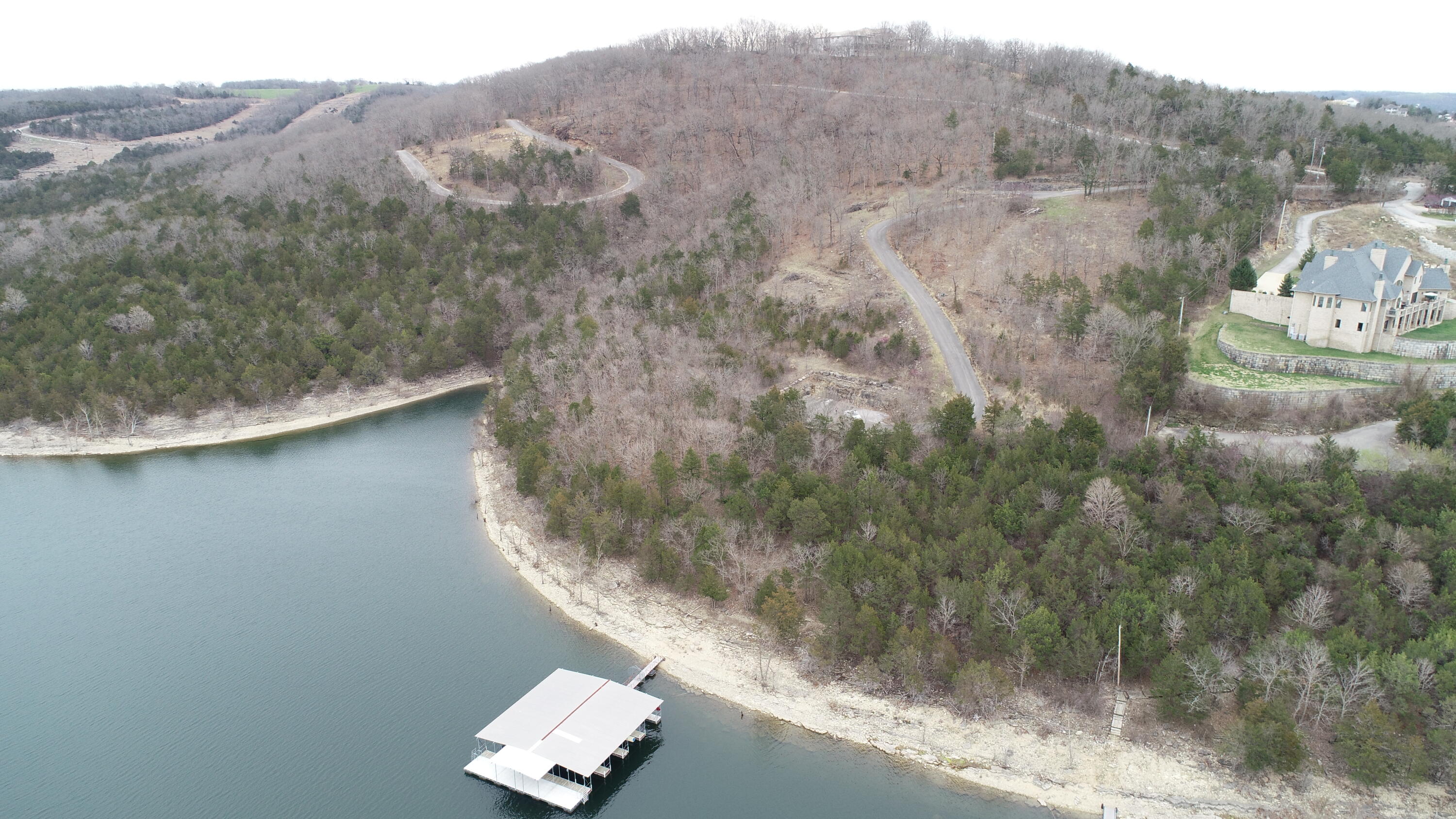 GATED 7+ acre HillTop Table Rock Lakefront tract! Hill Haven Estates dock with three 10'x24' slips available @ $55K each located at the end of your private drive w/new 10'x60' swim deck added in 2021. HUGE unobstructed Table Rock Lake views AND sunsets! Location- 10 minutes south of Branson short distance off 4-lane Hwy 65. Tract has been surveyed into 3 separate parcels if you wish to pick your neighbors or keep this rare find for yourself. By boat-Big Cedar, State Park Marina & Chateau on The Lake are all very close.