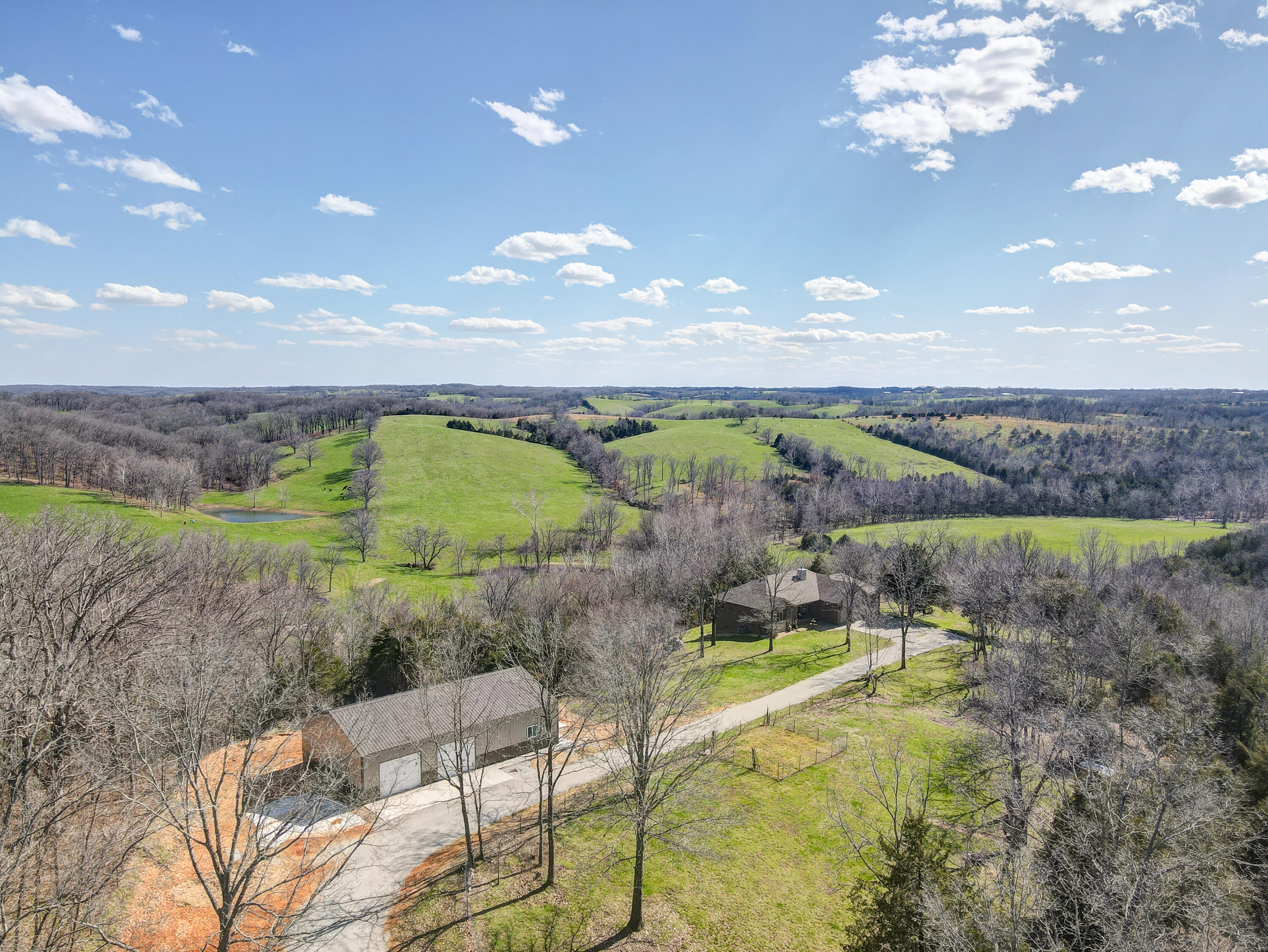 Walk out basement, all brick, 12 acres, 32x52 Shop (shop was built in 2021). This house/setting is absolutely amazing. The home was built in 2016 and features million dollar views. You will love sitting on the back deck overlooking thousands of rolling hills and ponds. The setting is very private with absolutely no restrictions. The home features 3 bedrooms and 3 bathrooms, open living/kitchen/dining room with large windows out the back. The floors are handscraped rough sawed pine. The basement features one of the bedrooms and bathrooms, open living room with fire place, wet bar, work out area/office. This home feels like it is brand new. It is so hard to find a home this well cared for with a shop on 12 acres and only 15 min to NIxa and 15 minutes to Branson West. This is a must see.