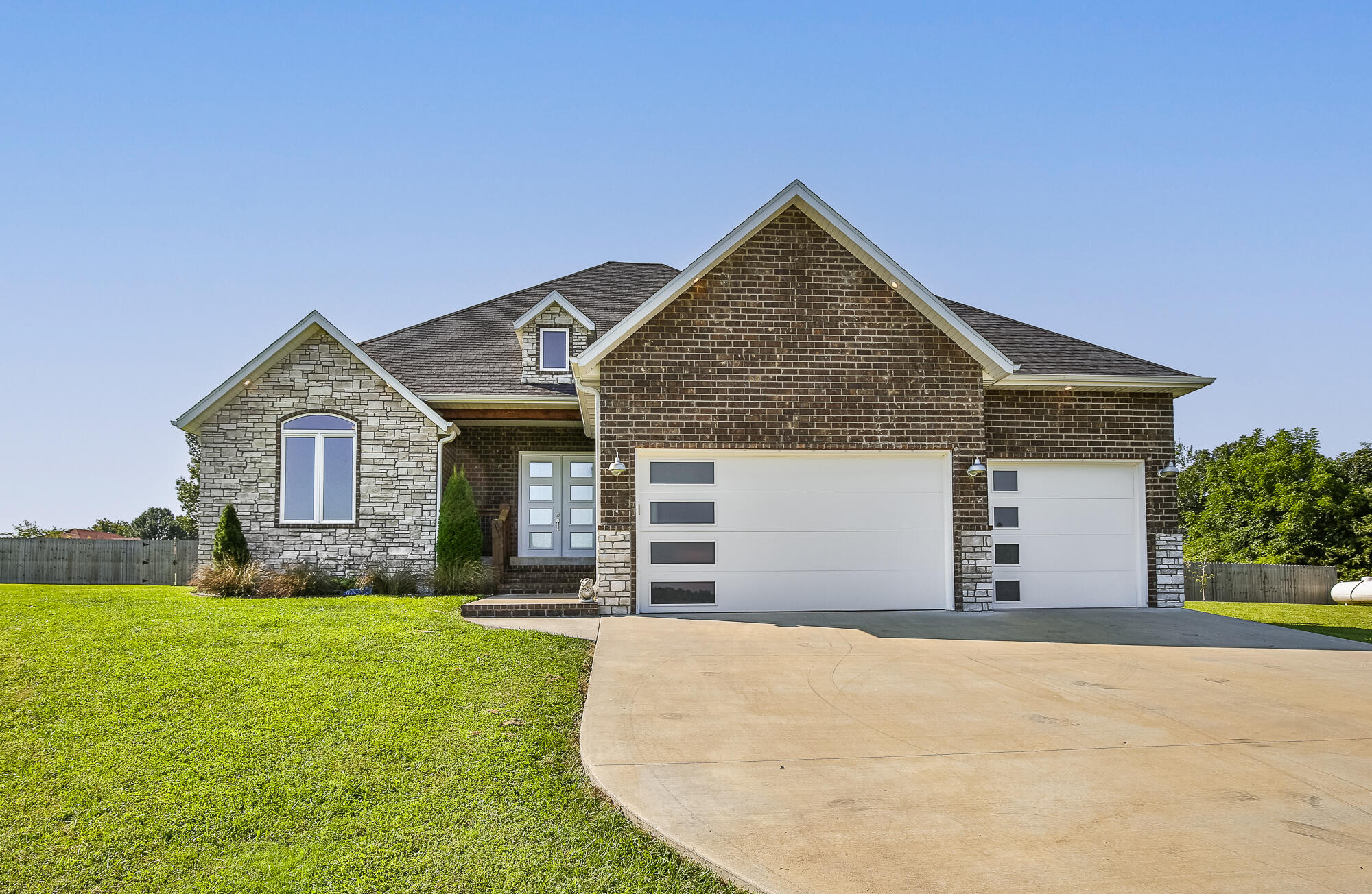 Custom built Nixa home for sale! Upon entering you will notice the open lay out of the living room, kitchen, and dining area. The kitchen has a beautiful island, stainless steel appliances, and large cabinets. Notable features include the 12 and 14ft ceilings, remote control blinds on the windows and huge walk in pantry! The primary bedroom is separate from the three other bedrooms. It boasts a five piece bathroom as well as a huge walk in closet.  The laundry room is in a great location between the primary closet and mud room, and is large enough for an office space. Located on two and a half acres in River Ridge Subdivision, you get the best of both worlds with a country setting yet close to Nixa Highschool as well as restaurants and stores. Outside you will find a private yard with a covered and screened in patio. Three sides of the yard are lined with large trees and there is a privacy fence. The pool and deck are included in the sale!