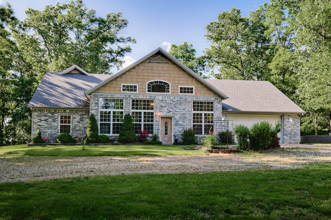 Beautiful custom home tucked away secluded on 40 acres. If you're looking for privacy, space, uniqueness, this is the one!! This property has so much to offer: Once you step foot into the home you walk into a heated/aired atrium then into the spacious living area featuring beautiful Oak doors, and trim throughout. Home features 3 bedrooms, 2 full baths, 2 bonus rooms, safe room, granite, stainless appliances, hickory kitchen cabinets, water treatment system and much more. Then walk outside, you have a large deck built in 2020 made of composite decking great for entertaining or relaxing enjoying your morning coffee. If hunting is your cup of tea..no worries; plenty of wildlife on the property for your hunting pleasure. Property also has a pond for the wildlife. Lets not forget about the 60x80 Shop..this shop has concrete flooring, electric, 2 offices, RV overhead stall, and 3 Overhead stalls. On the backside of the shop is an overhang with concrete flooring for additional storage for all outdoor equipment . The yard is beautifully landscaped with a waterfall in the front of the home, fenced garden, blackberry bushes and much more. To capture everything this property has to offer you must see!! Schedule your showing today! Property is a short drive to the new bypass making for a short drive to the NWA area.