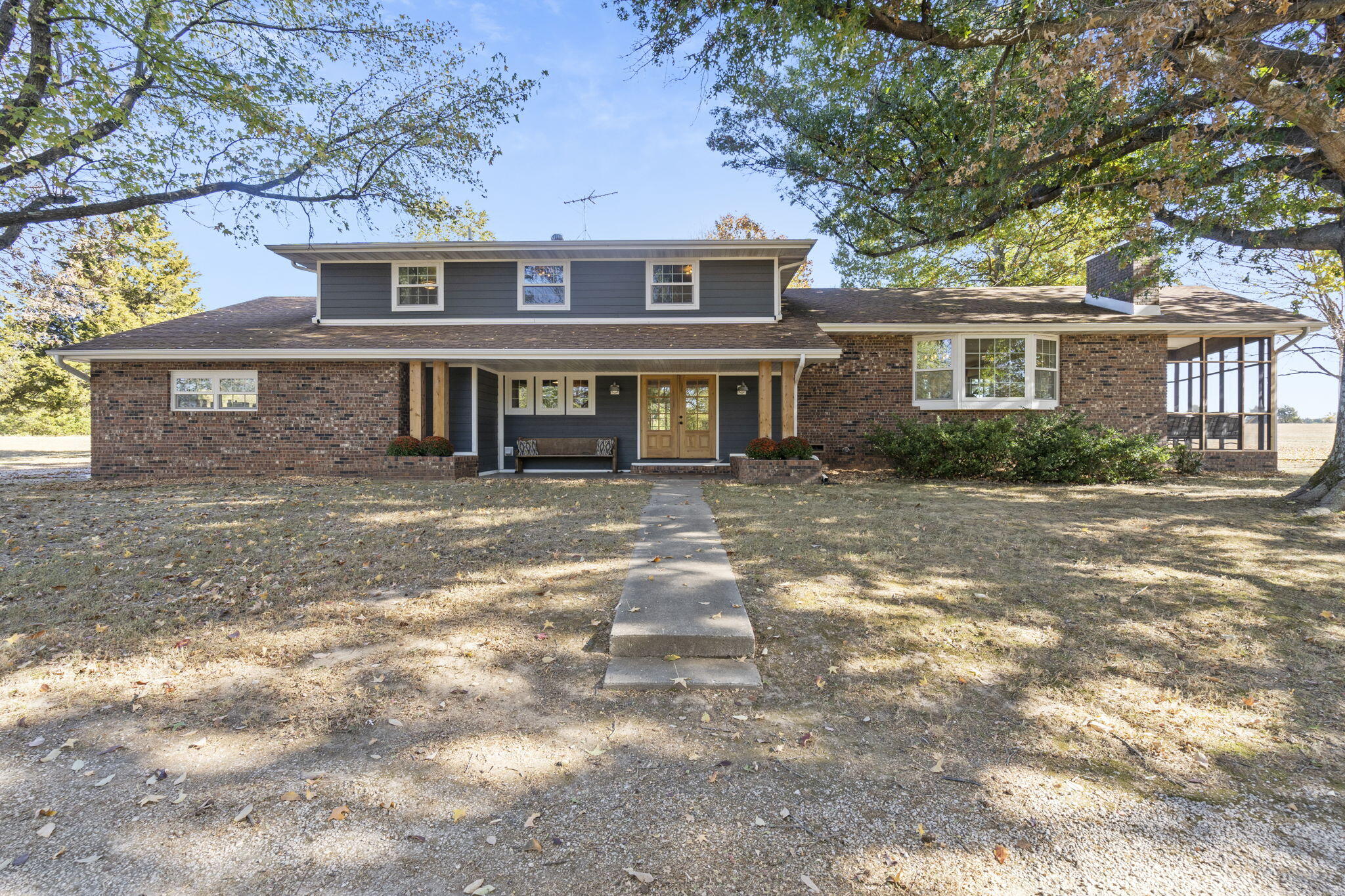 A true show-stopper. Beautifully updated and ready for you to make it a home, this peaceful property features a 5-bedroom, 2.5 bath house full of charm and entertaining space, 29 acres m/l, large shop and an amazing 40x60 hard oak barn with 3 horse stalls (10 stalls total). Situated just off of Kk and in Fair Grove Schools, you will enjoy peaceful pastures of hay ready to bail, with a quick and simple commute to Springfield. Inside the house, you'll find graceful updates at every turn. Gorgeous engineered flooring spans throughout the main level and into the drool-worthy kitchen, with its oversized island, quartz countertops, shiplap backsplash, beautiful light fixtures, ample light and hardware, soft-close drawers, and a large pantry. Right off of the kitchen, you'll find two sets of large sliding doors with two sitting areas where you can enjoy leading out to the large screened porch where you can enjoy stunning sunsets over the acreage and behind the barn. Entertaining will be a breeze here, too, with the open layout that flows seamlessly from one room to the next. Enjoy multiple living areas and gathering places, 3 wood-burning fireplaces, a fire pit, and a light-strung back porch. All of the entertaining spaces sit on one level, making it easy to invite guests over without them seeing the upstairs bedrooms, even if they are nice and tidy. And you're going to swoon over the primary suite, with its large bedroom, private balcony, soaker tub, large open shower, double vanity, and walk-in closet. Upstairs, you'll also find three additional bedrooms, a bathroom and adorable built-ins that are original to the home. Outdoors, enjoy the insulated shop with electricity (currently being used as a home gym) and the insulated barn with ample space for animals or a hobby farm.Option to split land available. See child listings: 60230639 and 60230644.