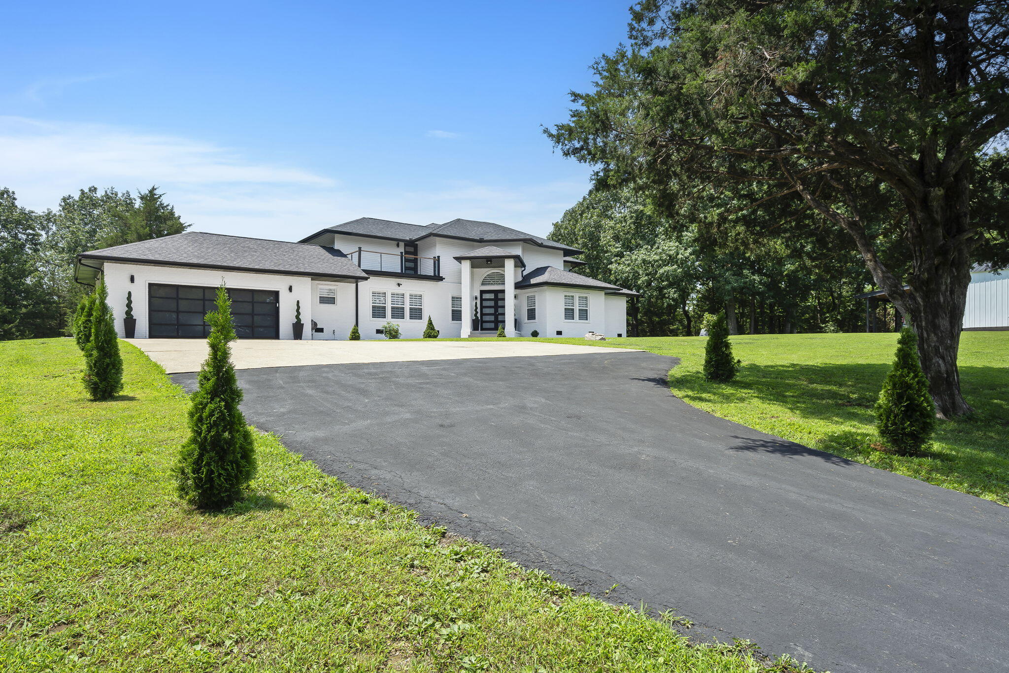 Stunning 4 bed, 4 bath walk-out basement home on almost 6 acres in Fair Grove! This gated property provides privacy and features a new roof, gutters, and HVAC! This contemporary home has been tastefully remodeled, with no detail overlooked and is ready for you to move in and relax. Inside, you are greeted by soaring ceilings, a spacious great room with a wall of windows, LVP flooring, and a 2-story fireplace. The kitchen boasts Quartz counters, custom cabinetry, a large island, gas range with a pot filler, walk-in pantry, and an adjacent dining room. The spacious primary suite has plenty of room for a sitting area, electric fireplace, private patio access, dual sink vanity, washer/dryer hookups, heated tile flooring, a large walk-in shower with jetted tub, and a walk-in closet with custom shelving. Completing the main floor is another bedroom, full bathroom, and a large laundry room. Upstairs provides 2 more bedrooms and a full bathroom. The walk-out basement could be its own apartment with a 2nd full kitchen, living room, bedroom, and full bathroom with washer and dryer hookups. You will love the garage space and multiple outdoor living areas on the patio and decks. There is also a paved firepit area, gardens, workshop with electric and a garage door, chicken coop, and ATV trails. Quick access to Hwy CC. Make this home yours today!