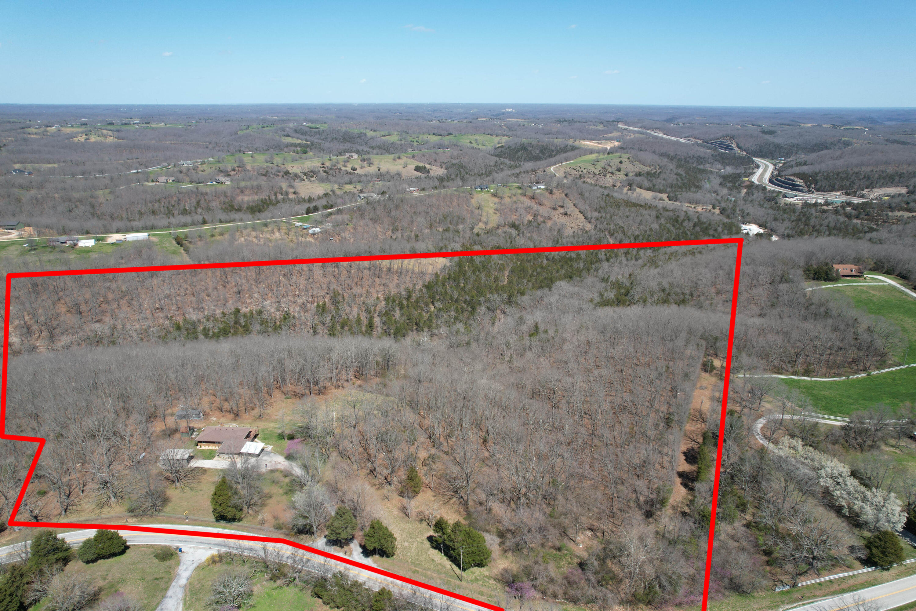 INCREDIBLE OPPORTUNITY TO OWN YOUR VERY OWN PIECE OF PARADISE ON 31.23 ACRES with NO Restrictions!!! PRIME location between Springfield and Branson tucked away in the gorgeous Ozarks mountains, yet just 1 mile off of Highway 65! With close proximity to THREE lakes, and ONLY 13 minutes to the Branson Landing or under 30 minutes to Springfield, this is the ONE you have been waiting for! The sprawling 31 acres is fenced on three sides and offers tons of potential with ABUNDANT wildlife, including deer, turkey and MORE! There is an ATV trail through the property, a small cave, natural spring and a wet weather creek to explore. This ALL brick and stone walkout basement home offering nearly 3000 square feet has been COMPLETELY remodeled from HEAD to TOE in the last 5 years and is BEAUTIFUL on the inside! Seriously, no stone was left unturned! Prepare to be impressed as you enter the property via the private paved driveway and newly installed electric gated entrance. Once inside, you will fall in LOVE with the modern farmhouse vibe, featuring a spacious open concept design with sweeping country views from the wall of windows! The main level features inviting paint colors and rich hardwood flooring throughout the living/kitchen/dining areas, with carpeted bedrooms and tiled laundry and bathrooms. The kitchen boasts beautiful granite countertops, new stainless-steel appliances, a large center island with lots of storage, an eat-in dining area with bay window and direct access to the expansive 80' wrap-around COMPOSITE deck (with cable railing), perfect for sipping your morning coffee, grilling or simply entertaining guests, while enjoying the breathtaking views!! Also, on the main level, there is a separate laundry room with barn door entry and generous storage AND not one, but TWO master suites (one with 2nd hallway access). NEW HVAC in 2021! Speaking of HVAC, this home enjoys TWO heating systems. One is a new (2021) central forced air propane unit and the second is an