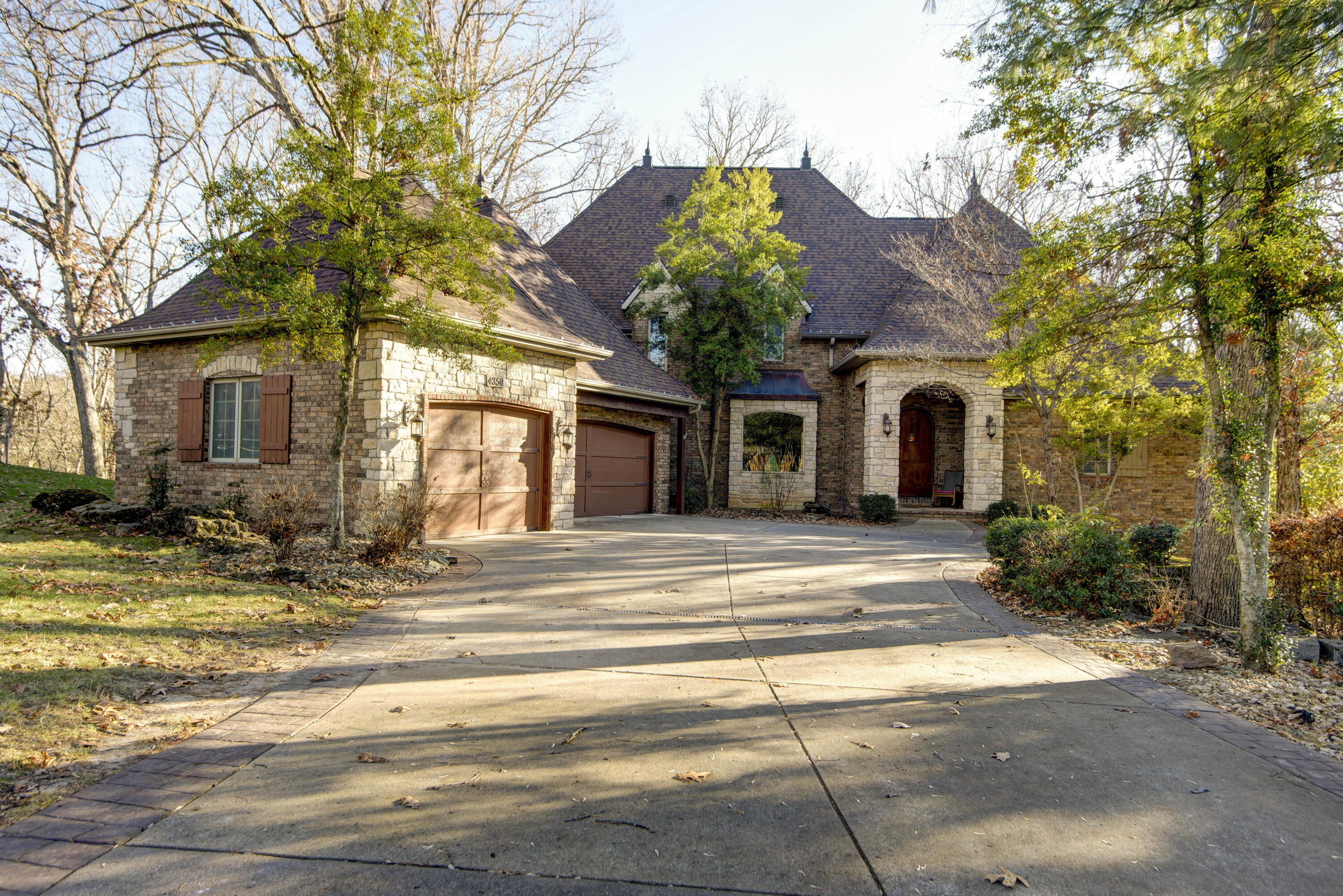 A calming view from every window is what you will find in this breathtaking home nestled onto the most premier lot in Emerald Park! The construction quality is amazing as well as the charm and character built into every corner. Huge wooden beams adorn the kitchen and hearth that date back to the 1800s with hand forged steel hangers. Stone walls and arched doors enhance the experience of warmth all thru the house. The main floor master sports an incredible spa type bathroom and private screened porch overlooking the woods and landscape. hand laid hickory and pecan floors flow thru the main level. Two stories of windows and stone fireplace with views of solid trees greet you in the formal living room. Every bedroom upstairs has a view, even the open loft! Huge game room basement with wet bar and fireplace. Side entry garage.and stone home which sits on slightly over a half acre.