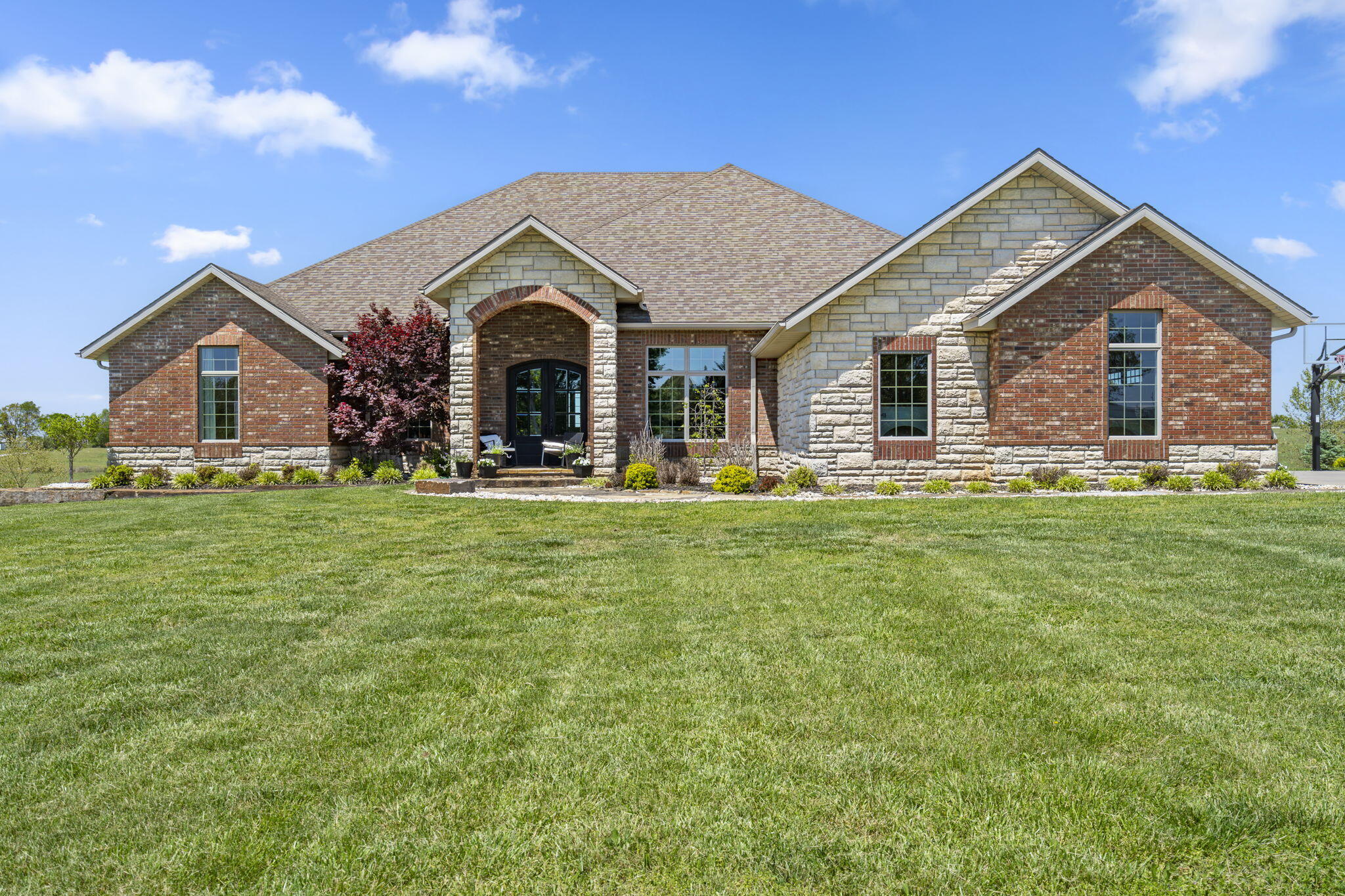High quality custom walkout basement home on 6 acres in Nixa schools! Three car attached garage and a 4 car detached garage/shop/recreational building with parking pad and paved private drive. Ideally located near Nixa and Ozark with easy Hwy 65 access to Springfield, Branson and Table Rock Lake! The home has a wide open floorplan with high vaulted ceilings and good natural light. It's ideal for hosting family gatherings or events. Good privacy with separation from neighbors. Geo-Thermal heating and air for consistently low utility bills. Large bedrooms, exercise and media rooms, lots of storage and a safe room. It's an ideal estate home with plenty of potential for additional customization. All brick and stone with spray foam insulation so even the attic is climate controlled. An additional 3 acres is available.