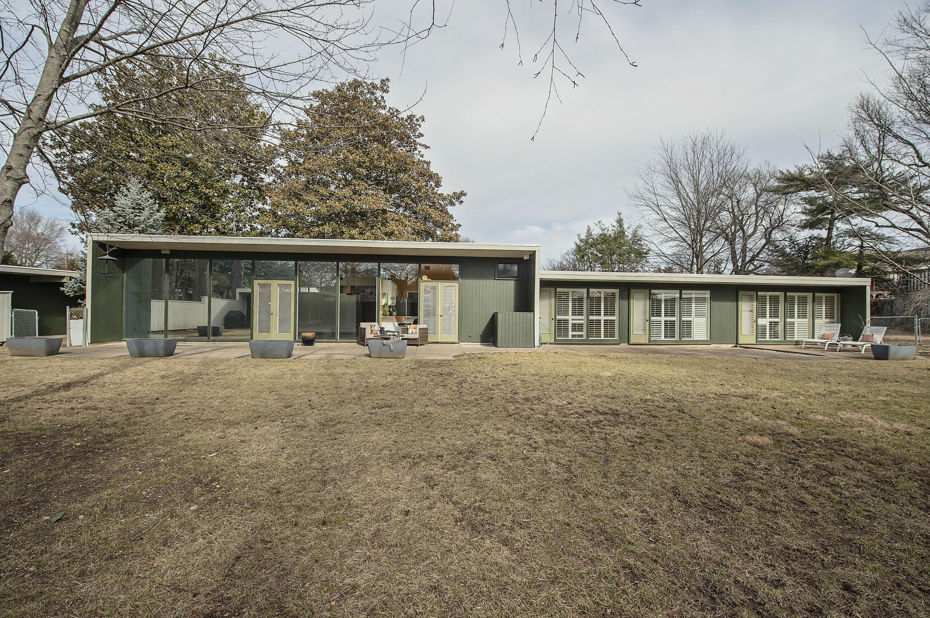 Immerse Yourself in Nature and Natural Light! This Rountree hidden gem holds a significant place in history, originally crafted by Architect Fred Shellanberger as a personal haven for his family's move from San Francisco to Springfield. Tucked away behind automatic gates, the home exudes privacy, with a unique perpendicular positioning to the street. Embodying the essence of midcentury modern design, the property boasts walls of floor-to-ceiling windows, sleek lines, and organic materials throughout. It is rare to find one level living and a 3-car garage ( Steel beam construction!).  This structure has a finished bonus room  which adds practicality and comfort to the space. Inside, the sustainable floor plan features open, flowing living areas, built-in storage, and a stunning hallway leading to 3 of the 4 bedrooms. Thoughtful upgrades have been made over the years, adding a TPO roof, installing glass garage doors, and updating gas lines, enhancing the home's functionality.  Former improvements include granite countertops, stainless steel appliances in the kitchen, and chic plantation shutters. This seller's meticulous restoration efforts extend to the exterior fencing, fresh paint inside and out, revitalized concrete floors, and new carpeting in most bedrooms, and thoughtful lighting choices. More guttering was added as well as a new hot water heater and adding a gas instead of electric stove.  Collaborating with Mashino's, a modern gas insert and was added to complement the home's aesthetic. Outside, the lush landscape, originally designed by a San Francisco landscape architecture firm sets a picturesque backdrop. The trees wewre recently mainted by All About Trees. A delightful screened summer house with a retro wood burner completes this idyllic retreat!