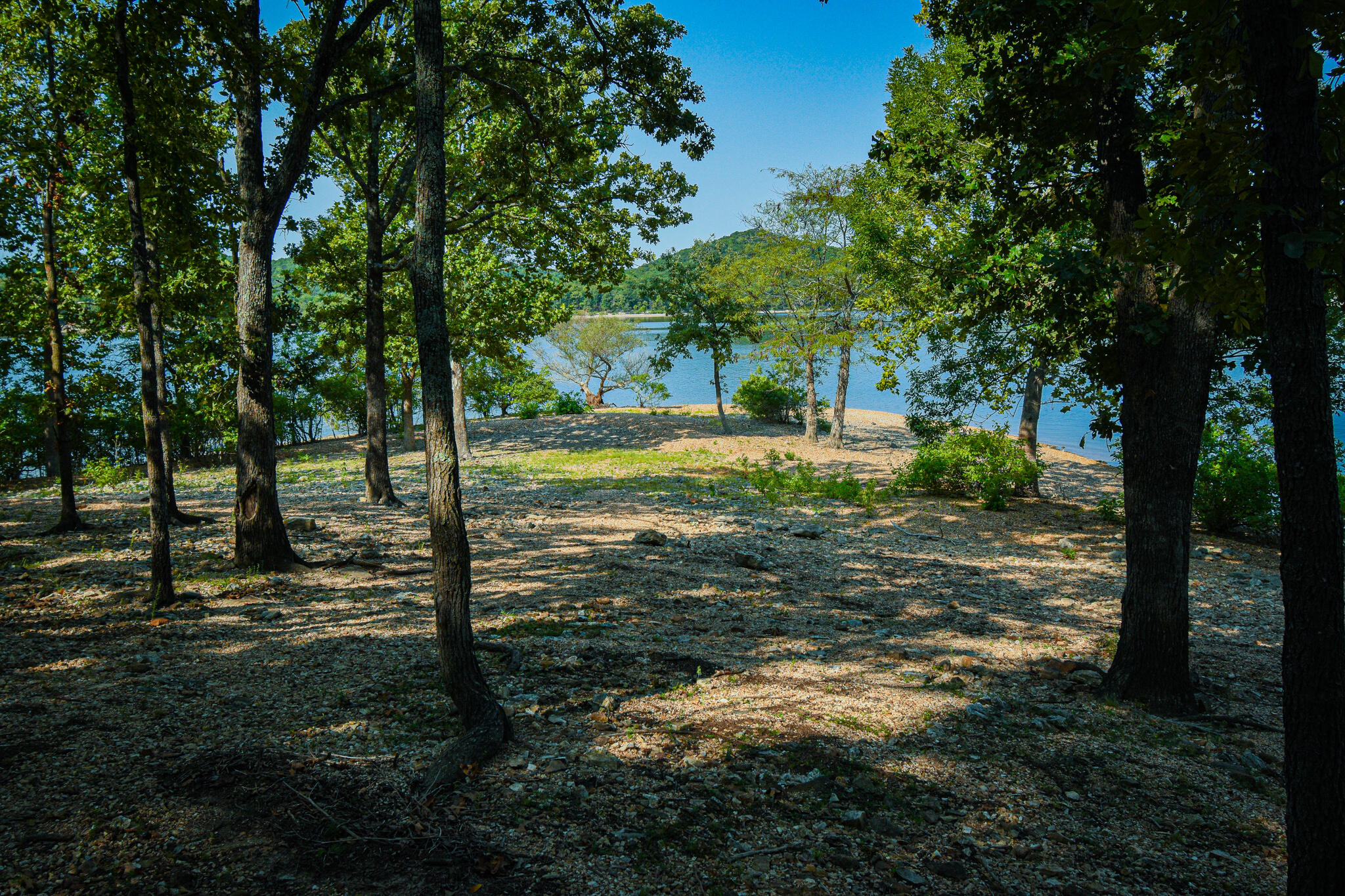 Incredible Table Rock Lake frontage and shoreline access with this secluded Pioneer Point property.  Pull your boat up to the beach and walk up to this entertainers dream home.  This stone and wood sided home sits deep on a 1.5 acre lot providing lots of privacy.  Tons of deck and patio space to enjoy.  As you walk into the main floor you're greeted with a beautiful living room with large beams and a stone fireplace.  Spacious  master suite, office, guest bedroom, and sun room are all located on the main floor.  Downstairs is perfect for entertaining your family and friends.  At the bottom of the stairs is a full kitchen, pantry, and living room  with another stone fireplace.  Venture further into the lower level of the home and you'll find a large formal dining room with excellent views of your private beach and the lake.  As you go past the dining area you will be led into a second lower level kitchen/bar that is truly the centerpiece of this lake house.  Open the large overhead doors, sit at the bar and enjoy your view of the lake. Over $100k worth of upgrades/repairs made in 2020.  Don't let this opportunity to own such a rare Table Rock Lake lot slip away.