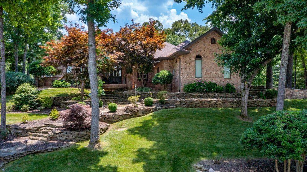 This home has remarkable elegance for formal entertaining yet comfortable for relaxing and enjoying life. It went under an extensive remodel in 2016 and has had extreme care since that time. This 4 bedroom 4 bath home is sitting on 1.58 acres that reminds you of a park with mature trees and beautiful landscaping for the discerning buyer. The home is located in Country Bluff Estates on the bluff and has some winter view of Lake Taneycomo below. The all brick one level home is 3340 sq ft of finished space featuring 50-year old Hickory Hardwood flooring with a chefs kitchen overlooking the Hearth room. The Hearth room has stunning floors and a brick fireplace which has a 3 piece canvas painting of Table Rock Lake. A wall of large windows to view the back yard looking out to enchanting gardens and trees. The Master Suite includes a newly installed marvelous custom designed Master closet in addition to the existing closet. The elegant bathroom has a heated floor, glassed walk-in shower and a long jetted soaking tub with auto rinse. All the bedrooms feature customized closets and 3 of the bedrooms have baths. Crown molding and LED lighting with dimmers throughout the home.  Formal Dining room has a 12 ft ceiling to the Formal Living room out the French doors overlooking the partial covered patio onto the stamped concrete walkway. There you will find two pavilions, hot tub, 75'' mounted smart TV, greenhouse shed with raised gardens beds and partially fenced beautiful back yard. 1.58 acres has sprinkler system throughout the property. See Special Features sheet with all the upgrades and features of the home. No Nightly Rentals. Listing agent is a relative of the sellers.