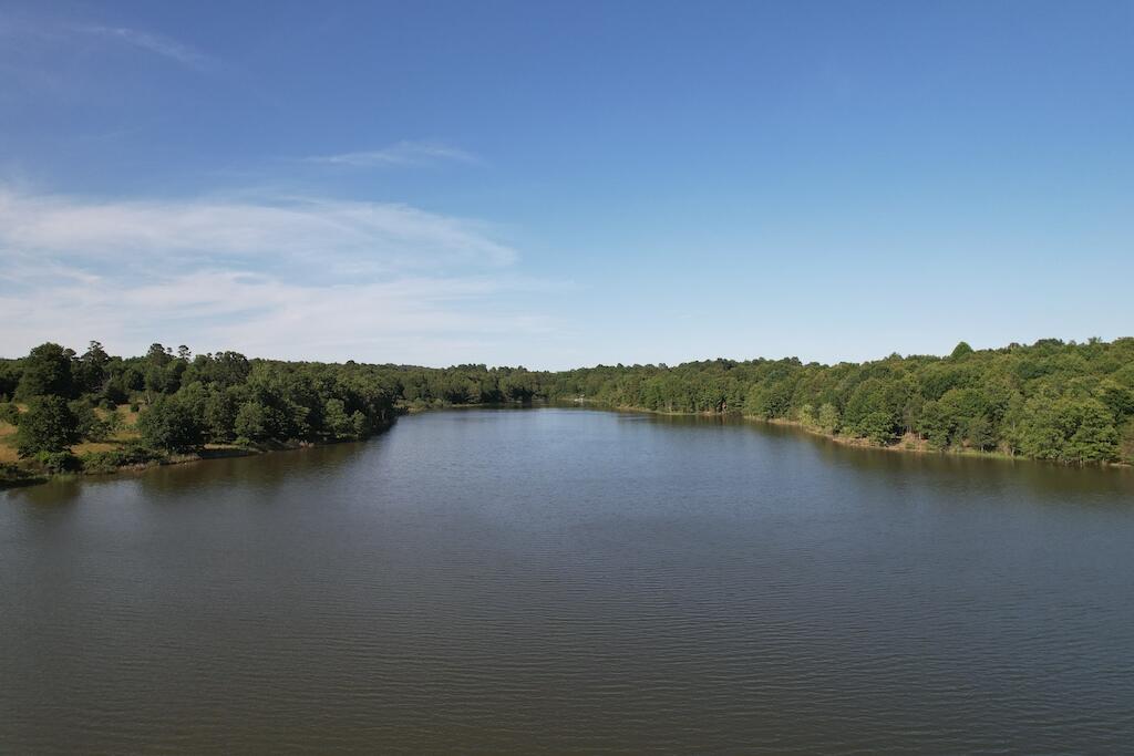 425 acres with 2 private lakes, smaller lake around 9 acres the larger lake near 15 acres both Spring fed. Land has been surveyed into lots approximately 10 acres with roads winding throughout, seller is not going to develop at this time just selling the entire piece in a single transaction. At least 2 additional ponds, 35 acres fenced in pasture balance is wooded. Access from 2 points onto 62/412 and an easement out the back of the property to a county road as well. There are Electric service lines running over some areas of the property, and Public water is run into the property with 2 meters paid for at this time , place them where you want them. There is a steel pipe cattle working corral that has not been used in several years and a boat dock on the 15 acre lake.