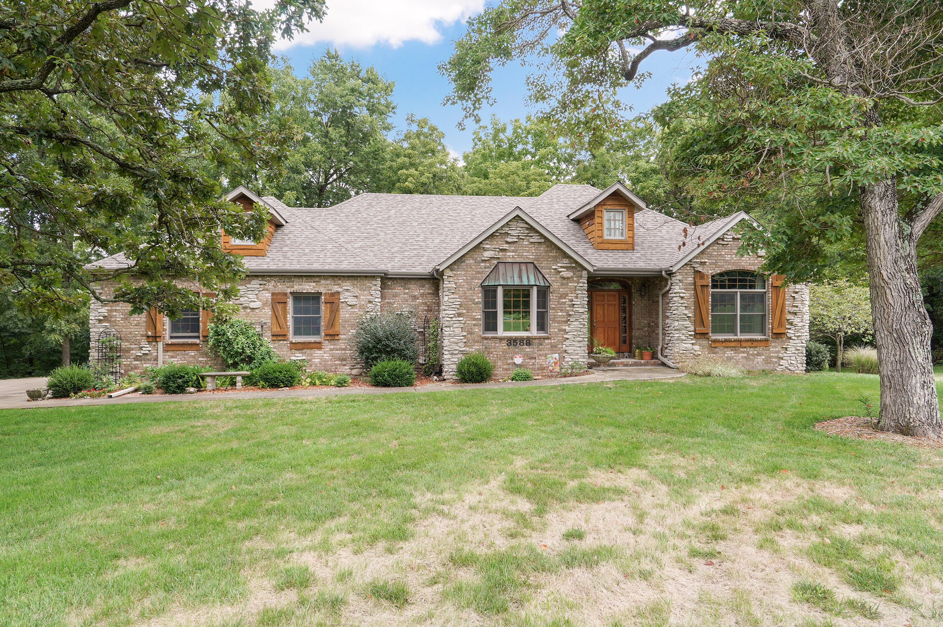 This is country living at its finest. It's an all brick custom built home with partially finished walk out basement on 10 + beautiful acres backing up to woods. The living room features a custom stone fireplace, vaulted ceiling with beams and windows to enjoy the views. The eat in kitchen has granite counters, stainless steel appliances, an island, an abundance of oak cabinetry and gleaming hardwood floors. Double doors off the kitchen lead to a large deck with retractable awning.  Three bedrooms are on the main level and feature the split plan.  The impressive master suite includes a fireplace, built ins, jetted tub, walk in shower and walk in closet. A laundry room, 2nd bathroom and office/den complete the main level.  Downstairs has so many possibilities.  There is a finished bathroom and bedroom.  The rest is great for storage or could be finished out for extra living space.  It is already wired and plumbed for a wet bar or second kitchen.  Here double doors lead to a patio that is wired for a hot tub. Other special features include wiring for a generator, coaxial cable and CAT-5 lines to every room, whole house attic fan and water filtration system.  The grounds are beautiful with a wet weather creek through the property and backing up to a wooded valley where deer, turkey and birds are frequent visitors.  Landscaping and manicured lawn surround the home.  In addition is a 30x 40 shop building with extra overhang storage area and 220 electricity and water.  This one owner home which has been lovingly cared for can now be yours.  Springfield address, Willard schools.