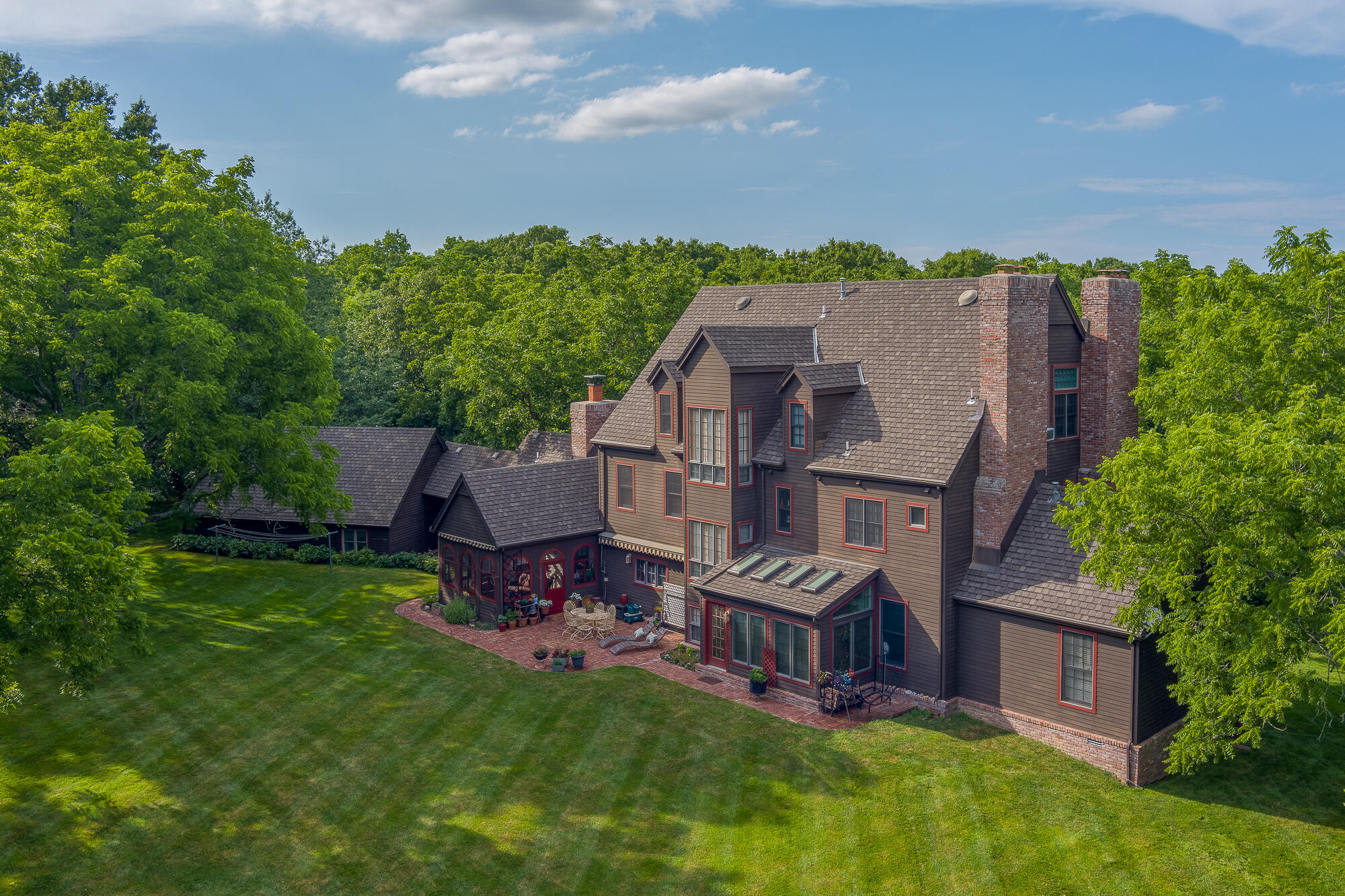 Welcome to a New England home in the middle of the Ozarks!  This is a custom built amazing home that has never been on the market.  The home offers unmatched details with a very private setting on approximately  21 ac. complete with a spring fed pond.  From the time you drive up the winding road you will be enchanted.  Sitting privately among towering trees is this stunning 3 story home plus a basement of over 8,000 sq ft that includes 6 bedrooms, 6 1/2 baths and 6 fireplaces.  Enjoy the 2-story foyer with a circle staircase plus a back staircase.  The formal dining room includes beautiful built-in cabinetry, wall decoration of hand painted murals, and wood flooring of pine that is throughout the home with exception of brick flooring in the kitchen and sunrooms.  The lower level is carpeted and baths are tiled.  Each room looks like a magazine photo.  The beamed kitchen is equipped with a 5-burner gas range, dual ovens, warming oven, built-in refrigerator, trash compactor, center island, beautiful cabinetry and is open to the kitchen dining area with a brick  fireplace.  Just off the kitchen is a screened patio.  A family room and library also have fireplaces.  Each room is beautifully finished with lovely details.  The second floor includes the spacious master bedroom with a fireplace, walk-in closet & full bath.  Two other large bedrooms are on this floor and 2 full baths plus a nursery.  The third floor includes 2 more spacious bedrooms (or hobby rooms), a full bath & storage. The lower level offers a very spacious recreation room, 6th fireplace,  bedroom, bath and 2 great storage areas.  Relax on the screened patio, the covered breezeway, back patio or the in-ground pool! A lawn sprinkler system waters the front and back lawns and is serviced by the private well as is the pool. Wander through the woods, explore the spring and catch fish in the pond.  This home and property offers a lifestyle the whole family will enjoy.  Located in Rogersville School district
