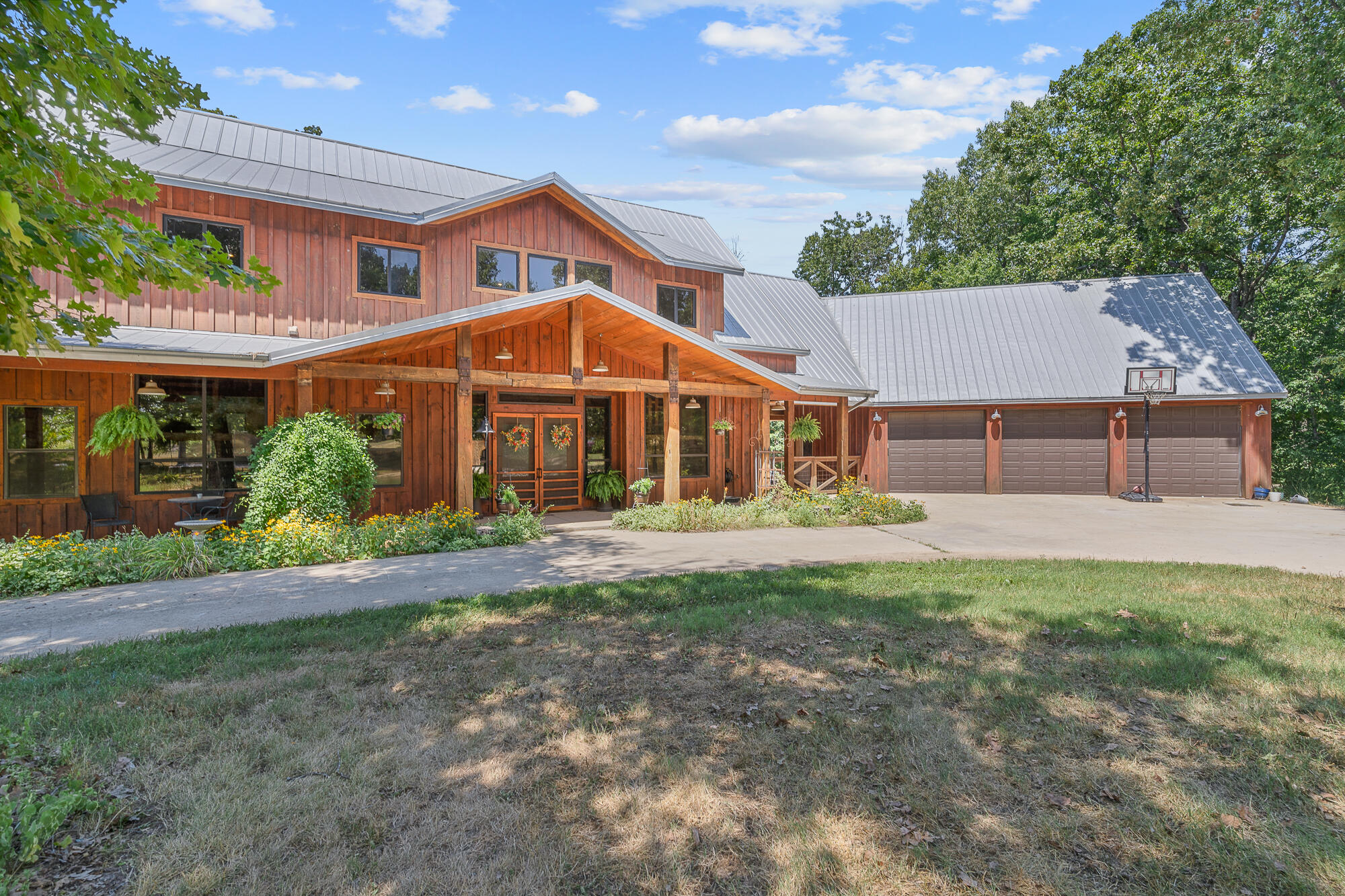 Wonderful opportunity to own to this private oasis on 16+ac. This custom built home is a timber frame style home with the timber milled from the property!  Looking for you very own secluded 'Yellowstone'.  This home is privately and peacefully secluded from all directions. The home is large and spacious.  It is excellent for entertaining either inside or outside.  This home has the look and feel of a lodge style resort and is a great place to raise a family and build memories.  Enjoy the out doors with the pool, the trails, the massive barn, micro or hobby farm.  Get your slice of the country life only 6 minutes to hwy. 65 and Sunshine street but yet so private.  The generous 2 story foyer offers a double door entryway to a spectacular custom staircase.  Upon entering the great room you will enjoy the 2 story flagstone woodburning fireplace and a lovely view of the in-ground pool and wooded back yard.  Custom wood flooring and wood posts add to the uniqueness of this home.  Double barn doors open to the second living area on the main floor with a gas fireplace enhanced with Oklahoma Flagstone.  This area is open to the large gourmet kitchen with a stainless countertop and granite counter top plus a center island snack bar.  A commercial gas range includes  double ovens and a stainless vent hood.  The kitchen includes a very large walk-in pantry and outside access to the large screened patio.  An office (or bedroom) and a full bath and half are also on the main floor.  The exceptional master ensuite is located upstairs with a beautiful full bath and    large walk-in closet.  Also upstairs are 2 more bedrooms, jac n jill bath and very spacious laundry room.  The  basement offers another rec area, bedroom and bath plus great storage and  storm shelter.  Fencing surrounds the perimeter of the pool and yard area.  The barn (56x80) actually could be an RV garage with 2-14 ft. doors and a loft (15X80)  for storage.  Many extra amenities to enjoy! Possible owner financing.
