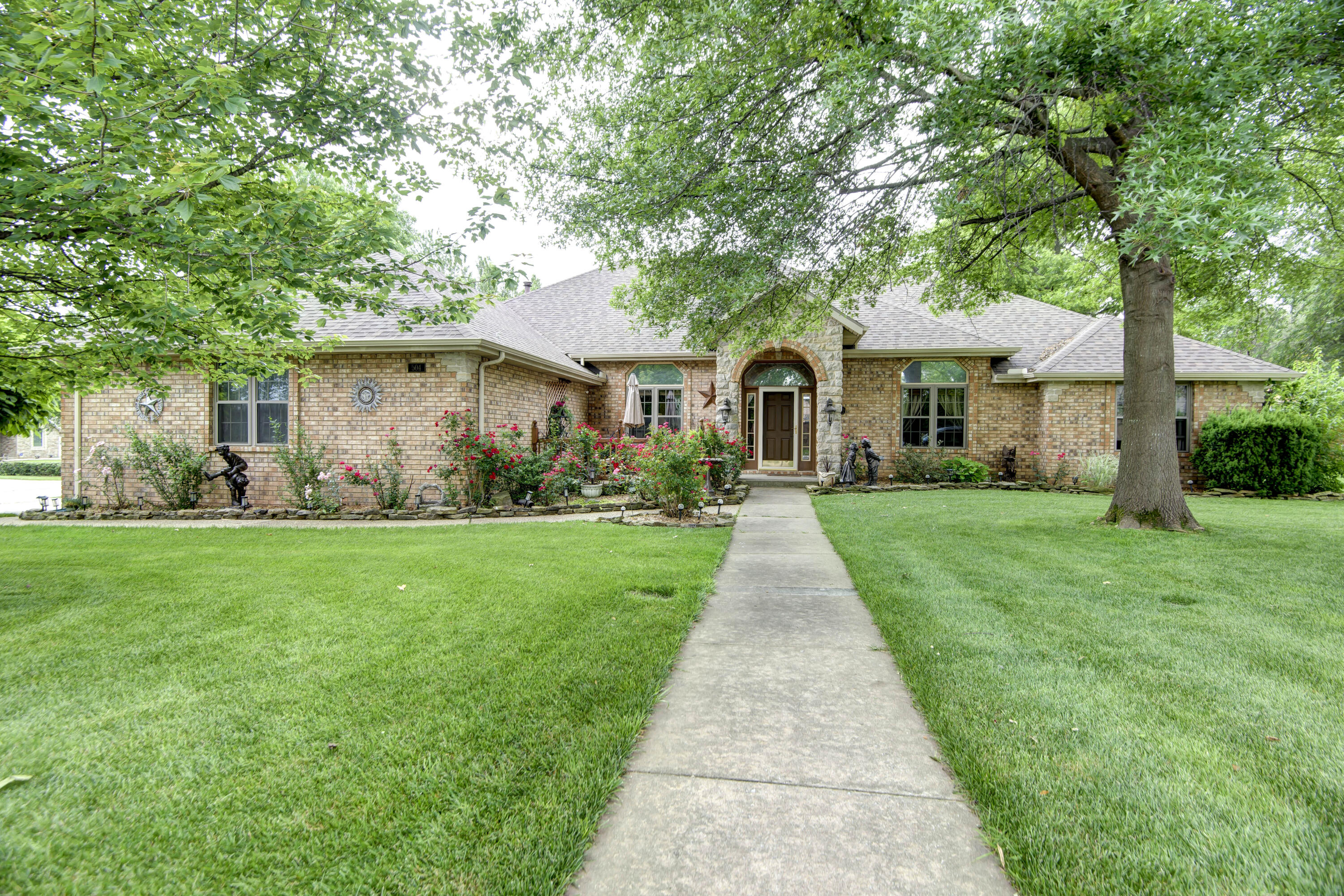 An incredible  ONE LEVEL 2838 SF home in Wasson Place with so many features. This all  brick home features split bedroom plan, 4 beds (each with walk in closet), 2 baths, 3 car garage (with hot and cold water), formal living, beautiful kitchen, heated and cooled sunroom, and heated and cooled tornado room complete with inground storm shelter, and front porch for coffee with the neighbors.  The kitchen has newer and refurbished cabinets, granite countertops, stainless appliances, an eat in area. and TWO pantries. Crown molding in dining room makes this an elegant entertaining area.  The master bath features a walk in shower plus a jacuzzi both with grab bars for safe access. Just off the living room is a small office area perfect for the remote worker.  Roof was replaced in 2021, crawl space has vapor barrier, and windows were replaced 3 years ago (except main bath window).  The back patio and deck feature a brand new (2023)  hot tub($9,000) used ONCE, three sheds for gardening, art projects, or mowing storage.  The backyard has a 6 ft privacy fence and the deck has an additional privacy area.  Perennial flowers and roses make this backyard a bird lover's paradise.  This double lot has a double gate for access into the backyard. Seller is furnishing a home warranty for your peace of mind.  This, my friends, is an incredible find.  Sale is contingent on seller finding acceptable home (she's actively shopping).