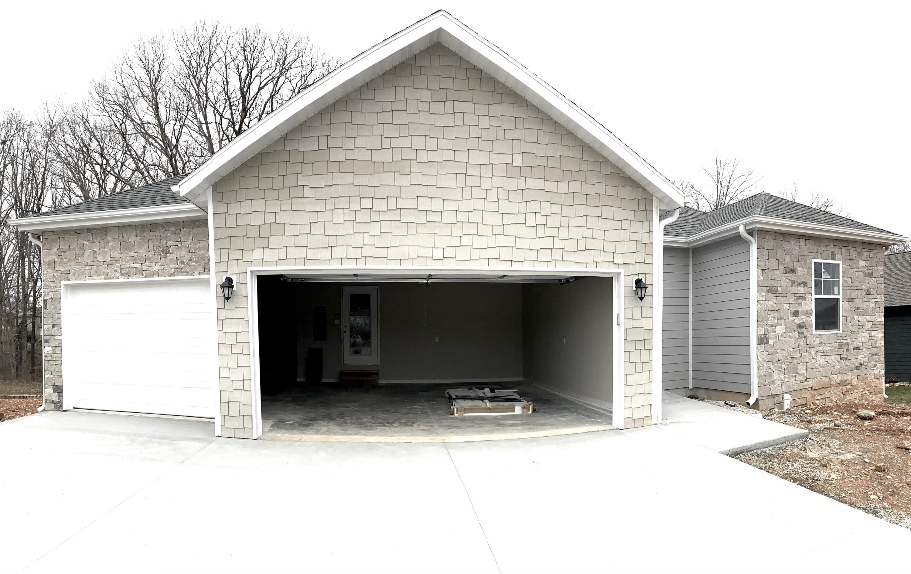 This spacious, 2327 square foot home will be ready to move in soon. ARE YOU READY for a BRAND NEW HOME in a beautiful subdivision that is quiet and neighborly. You walk down the street and see people riding bikes, walking, and talking to other neighbors on their gorgeous lawns. There are three bedrooms on the main level and a fourth downstairs. The Master Suite has a two grand closets with a garden tub as well as a large walk in shower. You would not believe the space their is to entertain. The open concept kitchen, dining and great room allow for ample room but then you go downstairs and experience the huge family game room. This home also has a John Deer room, perfect for the outdoor toys without using up garage space. The three car garage is ready for all of your lake toys. Enjoy your deck and lower level patio as you take in the dense trees that line the back of your property and listen to the stillness of nature. When you are ready to go out on the town you will find Silver Dollar City 10 minutes away, Branson 76 strip is just a short 15 minute drive. You also have at your access grocery stores, lumber yards, and a ton of great restaurants within 5 minutes. The perfect subdivision to plant your roots!