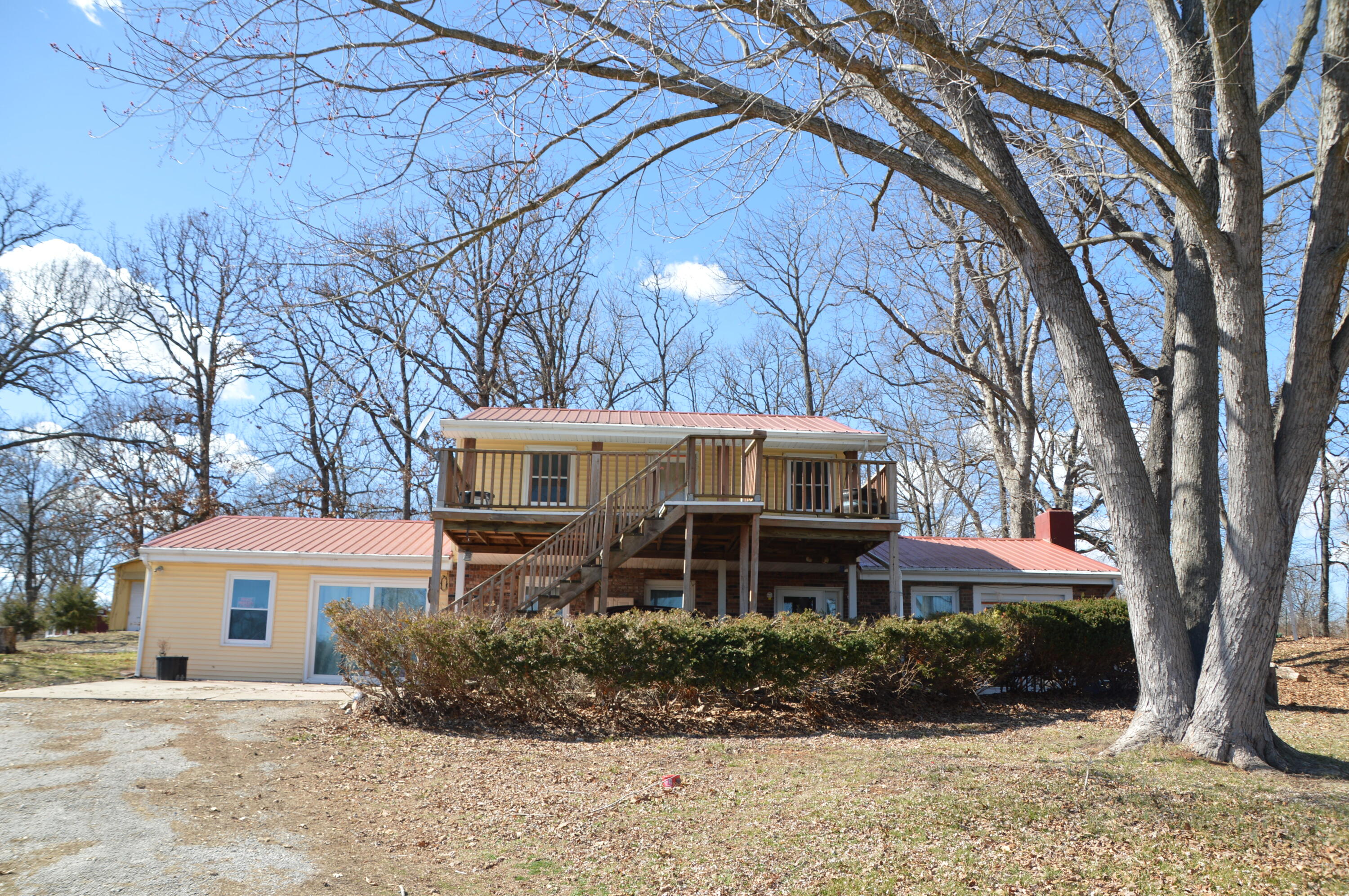 Looking for something close to the lake that you can call home? Then check this house out! Only a 1/2 mile Stockton Lake, this house could make a great lakeside retreat with some TLC. Home will need a lot of updating and repairs in the interior.  Sitting on one acre, you don't have to worry about being packed into a tight neighborhood. And the beautiful trees on the property offer some relaxing shade in the summer heat! The living room features high cathedral ceilings and a cozy wood burning fireplace. The deck off of the upstairs bedroom offers great views of the area. And don't forget about the detached garage. Home will need a lot of updating and repairs to the interior and garage.