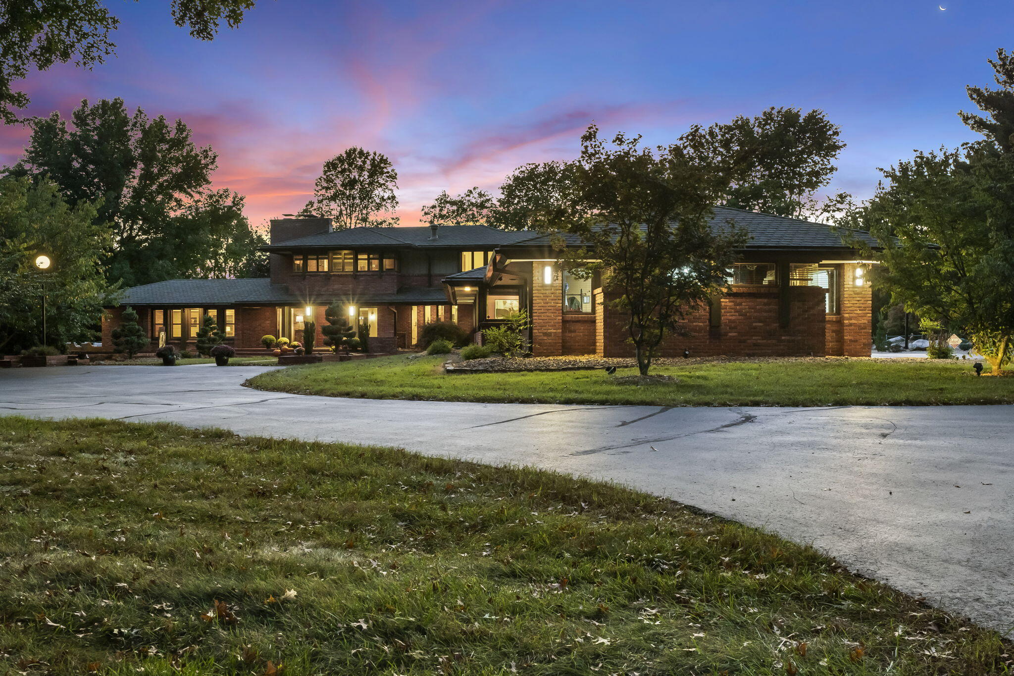 Updated and modernized Southern Hills home designed by Warren Bates and inspired by Frank Lloyd Wright. The remodel maintained unique original elements while adding luxury and convenience. This highly sought after home is situated on 2.58 acres and includes 4 bedrooms, all with en-suites, 4.5 bathrooms, 3 oversized living rooms, a spacious office, and a 3-car garage with circular driveway.The first living room features vaulted ceilings, the 1st of 5 fireplaces, and a built-in bar. The formal dining room boasts hickory hardwood flooring with a cherry/walnut inlay, and the hickory floors extend through the main level family room, kitchen, hallways, and powder room. The kitchen features Phenix marble leathered counters, Thermador appliances with a 36'' induction cooktop, warming drawer, built-in refrigerator, and so much more. It also includes custom walnut cabinets with a maple inlay by Ed Hines Cabinetry, a bar for seating, and a butler's pantry with sink, disposal, and dishwasher. Off the kitchen is a 2nd living room/hearth room with additional dining space, access to the back patio, and a beamed ceiling. The laundry room provides abundant storage and counter space and there is a nearby powder room for guests. The primary suite offers an oversized tile shower, dual sink vanity with Phenix marble counters, and a large walk-in closet with stackable washer/dryer and custom cabinetry. The main floor is completed by 2 more stunning bedrooms + bathrooms. Upstairs, there is an office w/built-ins, a private balcony, & the 4th bedroom/bathroom. Downstairs, enjoy an incredibly spacious living room with slate tile floors. Outside, there is covered patio space overlooking the acreage. Other features include: all Nest thermostats and smoke detectors, several new trees planted, 5 zone heating and cooling plus a dedicated primary bedroom mini-split heat pump, freshly sealed driveway, entryway bricks, and slate flooring. This highly coveted property won't be available for long