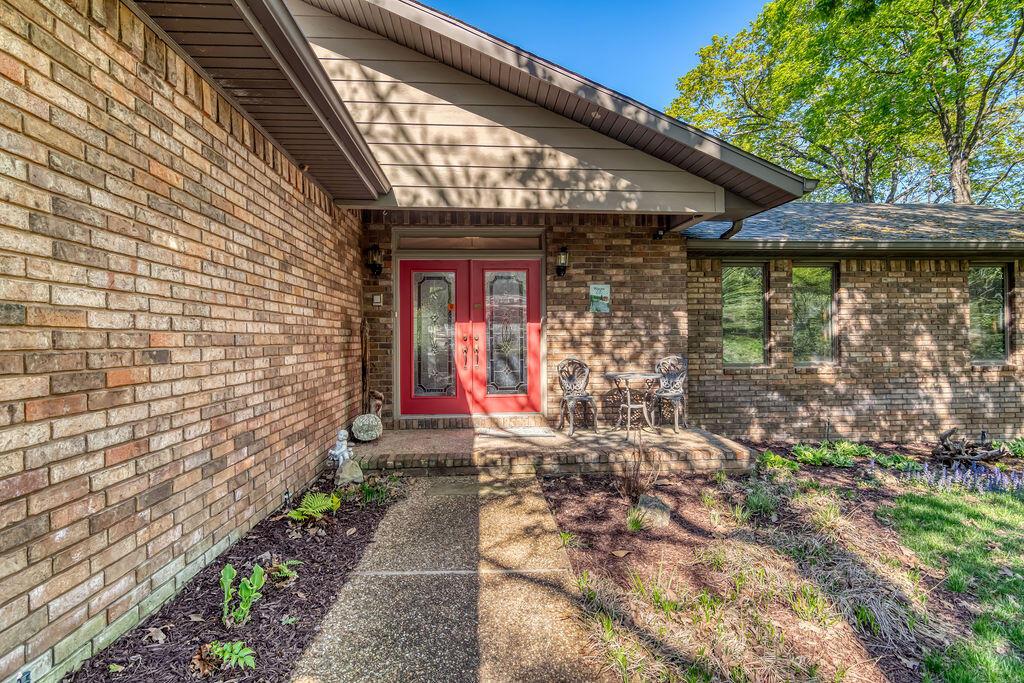 Spring has sprung at thisstunning lakefront home on 1.2 manicured acres and featuring a detached 1700 square foot workshop is what everyone is seeking. With 4 bedrooms, 2 full and 2 half baths, two living areas and a huge screened in porch, the home offers plenty of space for family and friends.  Amenities include a sprinkler system for the landscaped yard, generator, a central vacuum system, two cozy brick fireplaces, two car attached garage, a wet bar on each level and a fenced area for pets. Also available for additional dollars is a 11.5x24 boat slip just a short distance away in the community.   This is the perfect time to view this home as the spring blooms are gorgeous.