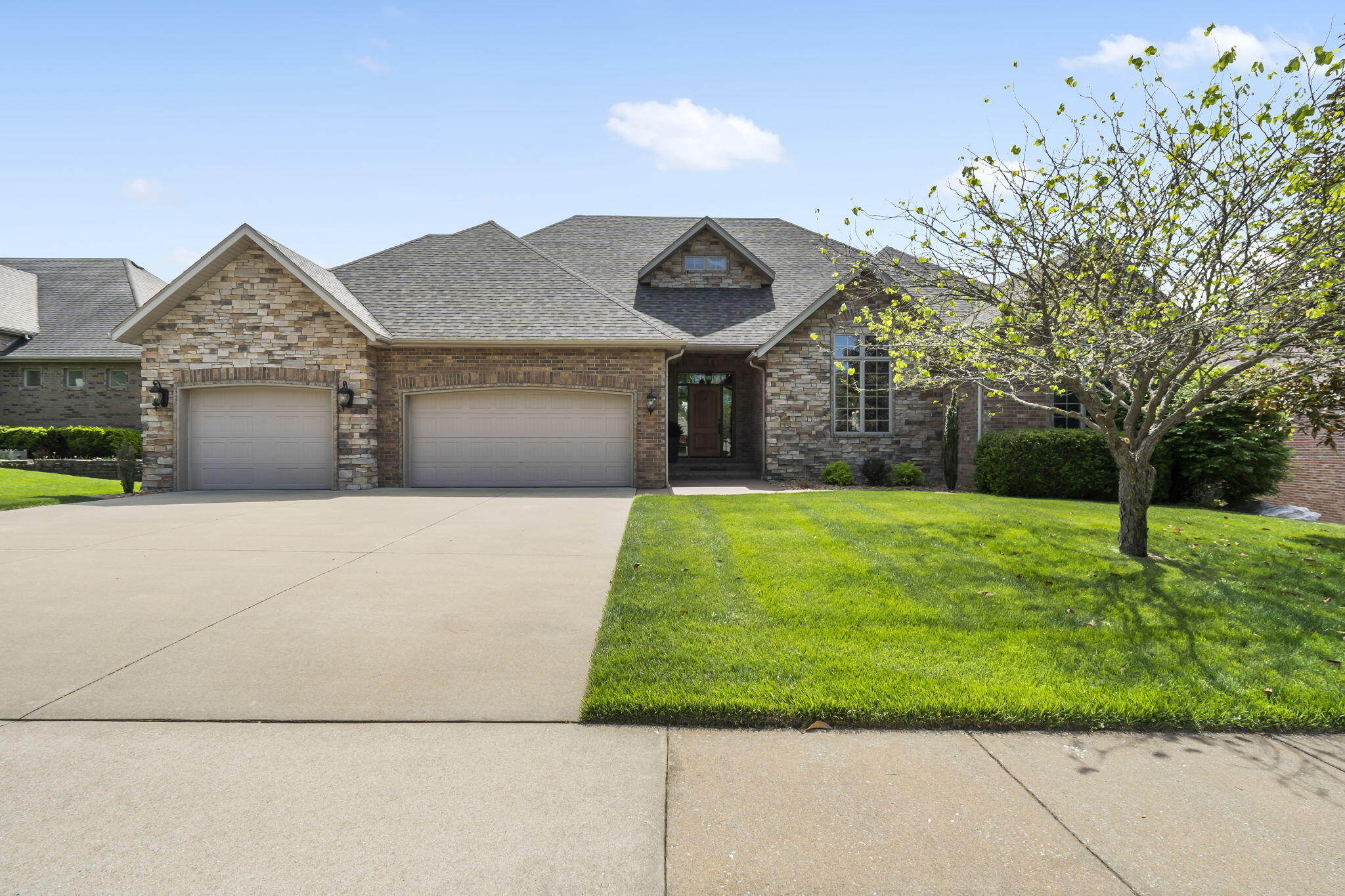 Stunning all brick + stone home in the exclusive gated community of Windsmore.  Featuring 4 beds, 3 baths, and a walk-out basement with a 2nd kitchen and wine cellar.  Inside, the main floor is nice and open with tall ceilings, hardwood floors, and a gas fireplace.  The spacious kitchen features a large bar with granite counters, hickory cabinets, stainless appliances including a gas range, pantry, and attached dining space.  The large primary bedroom include access to the screened in deck, dual vanities, jetted tub, walk-in shower, and walk-in closet with custom cabinets.  Completing the main floor are two more bedrooms with vaulted ceilings, and a full bathroom.   Downstairs, discover a large recreation room with plenty of space for game tables, dining, and a 2nd living room.  There is also a full 2nd kitchen, wine cellar, gym, bedroom, and full bathroom.  The screened in patio overlooks the beautifully landscaped yard and has a covered patio beneath it.  Quick access to Hwy 65, Hickory Hills Country Club, and more!