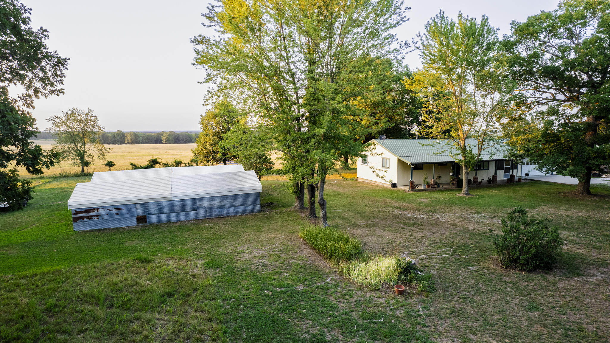 Grab your chickens and a few calves...You found it!!  Country Living!!  Home in the country with 17 acres. . 2 nice size bedrooms and nice large bathroom.  8.5 acres in back of home is completely fenced and current use is for hay. Large deer stand stays on the property.   Oak trees, amazing front porch, metal roof only a few years old.  2 car garage. 1/2 bath in garage. RV hook-up, well house doubles as storm shelter.  Septic system includes new tank, risers and clean out. Water heater installed in 2019. Home includes wood stove in living room and open floor plan.  Raised garden beds, storage shed, 2 large carports. Appliances included in home are Propane cooking stove, white refrigerator and washer/dryer. Flower pots on front porch do not stay.