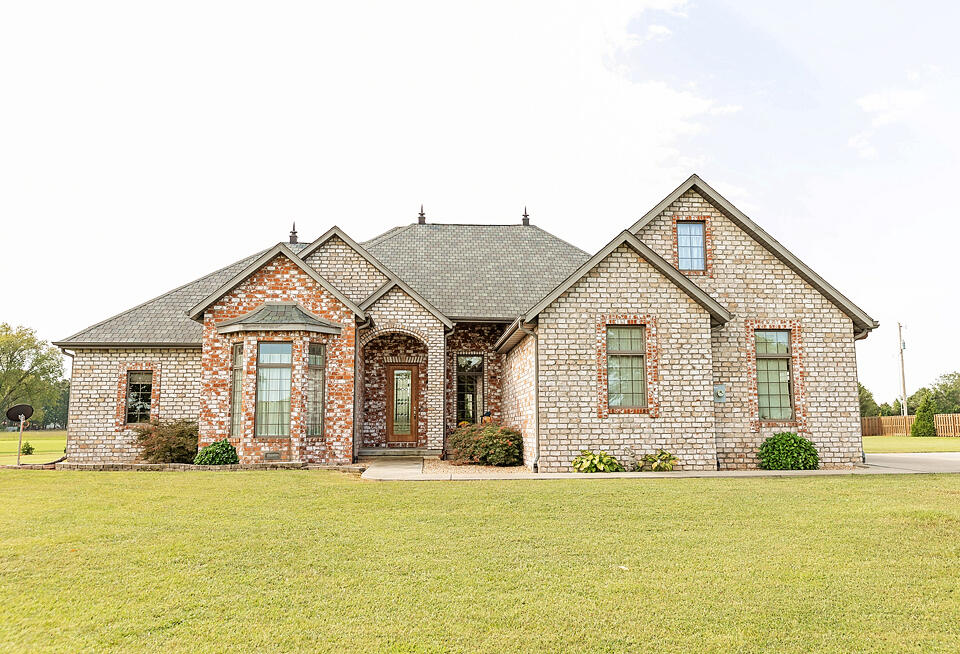 PRICE IMPROVEMENT!! Welcome to this impeccably crafted French Provincial home, a true testament to quality construction and luxurious living. Situated on 5 acres of beautifully landscaped grounds, this builder's personal residence offers timeless elegance and modern amenities. The exterior boasts Pennsylvania handmade brick, a 50-year warranty roof, and a garage wired for an electric car. Safety and convenience meet with a storm shelter under the front porch, complete with lights. Anderson windows and an 80-gallon hot water heater add to the home's efficiency and comfort.Inside, an open floor plan with abundant windows creates a bright and inviting space, perfect for hosting gatherings. The kitchen is a chef's delight, with beautiful faux-painted cabinets, an island, and a spacious bar. The pantry is generously sized, and the appliances, including a double drawer dishwasher and a nearly new refrigerator, are top-notch.The master suite and bathroom are a true sanctuary, featuring a double vanity, soaker tub, washer and dryer, and a dream-worthy walk-in closet. Privacy is assured with the third bedroom located upstairs, perfect for teens or guests.Outdoors, a covered porch leads to a versatile 21x21 all-brick Hobby Shop. While the sellers currently house pigeons here, the possibilities are endless, whether you envision a greenhouse, craft shop, or additional living space.The beautifully landscaped 5-acre property provides a private oasis. This home is a rare find that will exceed your expectations, don't miss the opportunity to view this exceptional property!