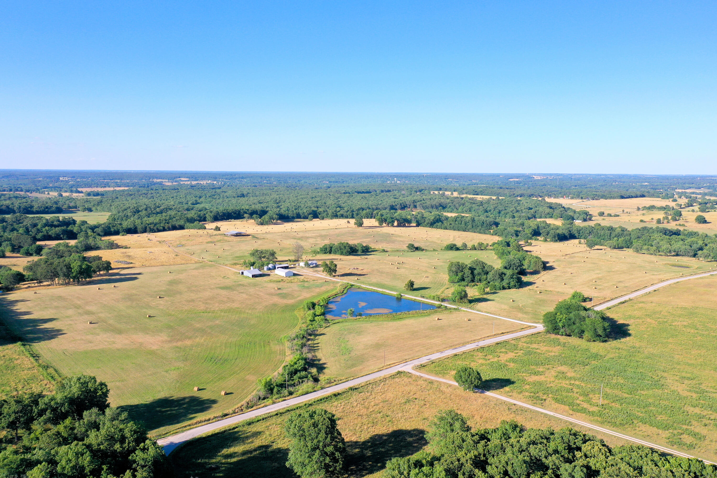 Well cared for farm located in Polk County, MO.  This gently rolling 200 m/l cattle ranch is perimeter fenced, crossed fenced, has ample water sources, corrals and several functional barns.  The fescue based forage on gently rolling acreage has been managed for many years and shows with its high yields even in the drought days behind us.  With 100 plus acres being mowable for hay production and the pole barns to store the hay in this could also be an option income production.  The home is a 3 bed 2 bath modular on a permanent foundation and has a storm shelter for peace of mind.  6 bays of parking for the rigs, tractors and equipment along side a large shop with concrete floor and electric.  This farm has been cared for with a high level of pride and it shows.