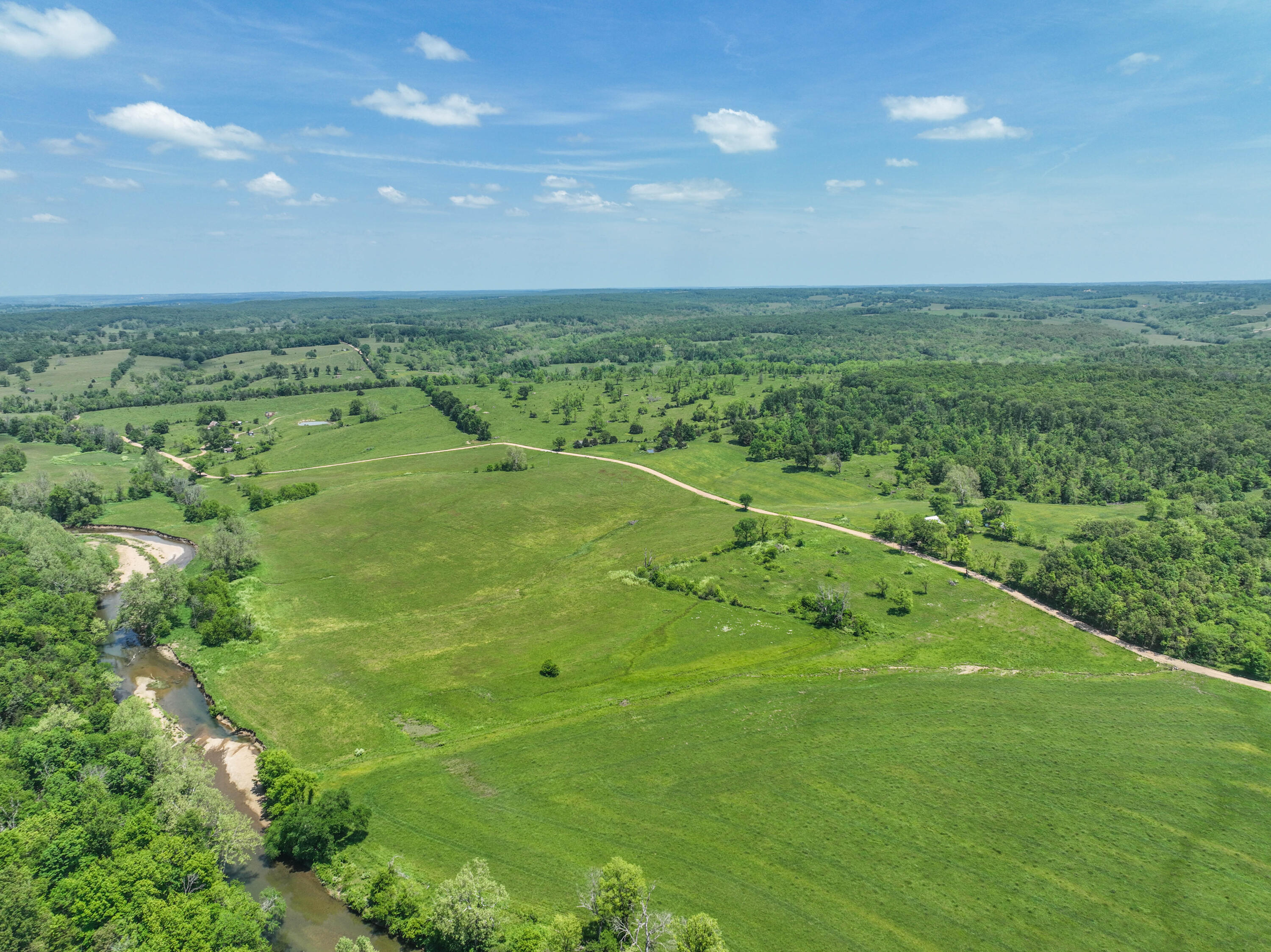 Ranch in the Missouri Ozarks For Sale!  352.5 Acres m/l with Beaver Creek Bottom Ground - Mountain Grove, Missouri - Lots of water! Fantastic Views!With multiple springs, ponds, and creeks - including Beaver Creek, North Fork of Beaver Creek, and Sugar Creek this property is perfect for ranching, hunting, recreation, and building. The layout of this cattle farm features easy access from the county road at multiple points on the property. There are several barns, outbuildings, and many beautiful building sites with views of your hay bottoms. There are also two old homesteads on the property.The property is primarily open and in pasture with a good mixture of trees. With a variety of topography, the property has rolling pastures with views, flat bottom ground, steep creek bluffs, and hidden pockets of fields throughout the northernmost acreage. The farm is currently leased for hay and grazing.Experience the varieties of ground the Ozarks provide. You may want to stay!