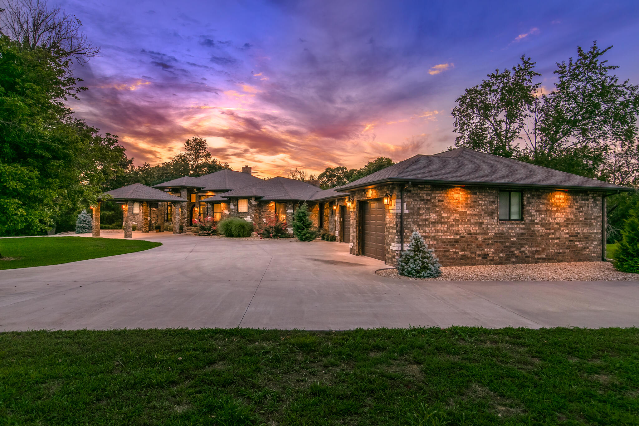 Stunning one level brick home on 37 acres with 3 beds + office, 3 baths, a 3 car garage, and a 2400 SF shop!  This home is located minutes from Springfield on a scenic road in Ozark with 1/4 mile of Finley River frontage.  The private, gated drive crosses over Hog Creek and ends in a circular drive to the home.  The driveway has covered parking in front of the entryway as you walk up to the custom designed iron front door.  Inside, you will find 18' porcelain tile floors installed at an angle throughout the home.  The ceilings range from 9-14' and the Argon gas insulated Anderson windows provide abundant natural light.  The front of the home features a formal dining room, office with French doors and built-ins, and the formal living room with masonry fireplace.  The spacious kitchen features soft close oak cabinets, granite counters, an oversized bar + island, Electrolux stainless steel appliances, a Kobe commercial grade range vent, and a walk-in pantry.  Off the kitchen is a 2nd dining space with exterior access, family room with vaulted ceilings and see-thru fireplace, and a coffee bar with a sink and beverage fridge.  Through french doors is a media room/2nd office with oak built-ins.  Master bedroom features tray ceilings, his and hers vanities and walk in closets, a jacuzzi tub, and a walk-in shower.  2 bedrooms share a jack-n-jill bathroom.  There is one more full bathroom and a large laundry room with ample cabinets.  The beautiful outdoor space features a covered porch and the 40x60 shop.  The shop has a concrete foundation, is insulated with 220 volt power, and has two 9x12 garage doors. Other prime features include a whole home and garage central vacuum system, soffit plugs for Christmas lights, and full LED lights throughout.  With walking distance to the river, this luxury home is a rare find in an amazing location.  Call to schedule your tour today!  For a full list of features, please visit the listing photos.