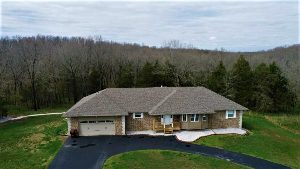 No neighbors in sight on this 2.63+/-acre, walkout basement home nestled on a private road in Nixa.  This home has been remodeled and is ready to face the next 20+ years. Steel siding on the exterior, new roof and all new decks to enjoy your natural oasis. The main level is bright and open with tall ceilings and an abundance of natural light. Kitchen has a great foot print and plenty of cabinets. Dining area roomy enough for a farm house table. Lower level features a full kitchen, family room and two bedrooms. It also has a workshop with 20amp service and storm shelter/safe room. All new interior paint, remodeled bathrooms, LED lighting, new carpet and porcelain tile through out.This one is not just a house, it's a home!