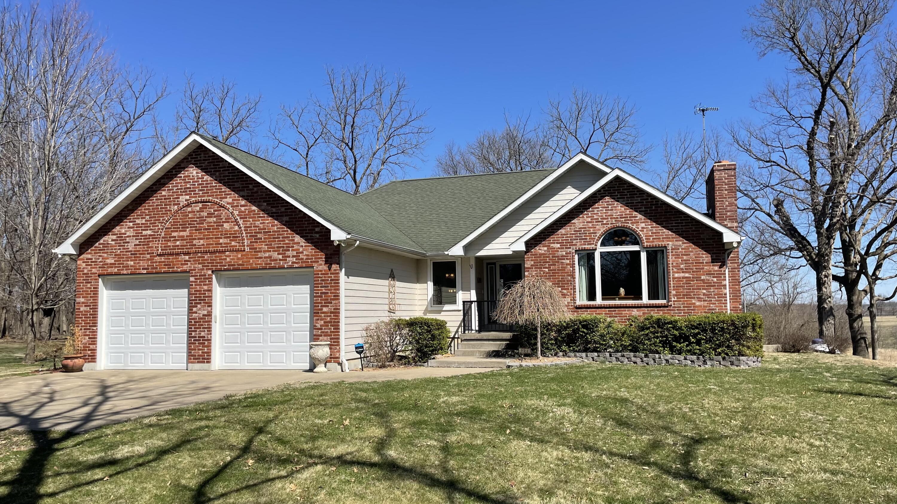 Welcome home to 14285 County Road, Weaubleau MO, located on 10 acres that has everything you need for easy living!  Don't miss out on the gorgeous views of the large yard with mature trees in a rural park-like setting.  This beautiful custom-built country home (3339 sq ft. / 3 BD / 3 BA) has a maintenance-free exterior (Brick and Hardy-board siding) with hardwood and tile floors throughout the main level of home.  The home features a great chef kitchen with dining area, a large great room with a wood-burning fireplace, a first-floor master with ensuite, a large 2-car garage that has access to the basement.   Kitchen features custom hickory cabinets, granite counters, and stainless appliances.   Spacious Great Room features big bright windows, vaulted ceiling, and a woodburning-fireplace that is ducted throughout the home.  Additional living space on the lower level has a living area with a gas fireplace, that is perfect for enjoying time with family.   The lower-level features a bedroom, exercise/office room, family game area, bathroom with a private cedar-lined sauna, large pantry and storage area.   In addition to the attached 2 car garage, there is a separate 30x50 insulated garage with concrete floors, electricity, and water: Great for a workshop and all your recreational toys.   A partially-cover back deck with composite deck flooring completes the livability of the home with views of the pool area and back yard; it's perfect for family gatherings and summertime BBQ's.  Home is centrally located for all of the area lakes recreation, within minutes of Pomme de Terre lake, and has easy access to MO Hwy 54.   This is AN OPPORTUNITY YOU HAVE BEEN WAITING FOR!  Come and See