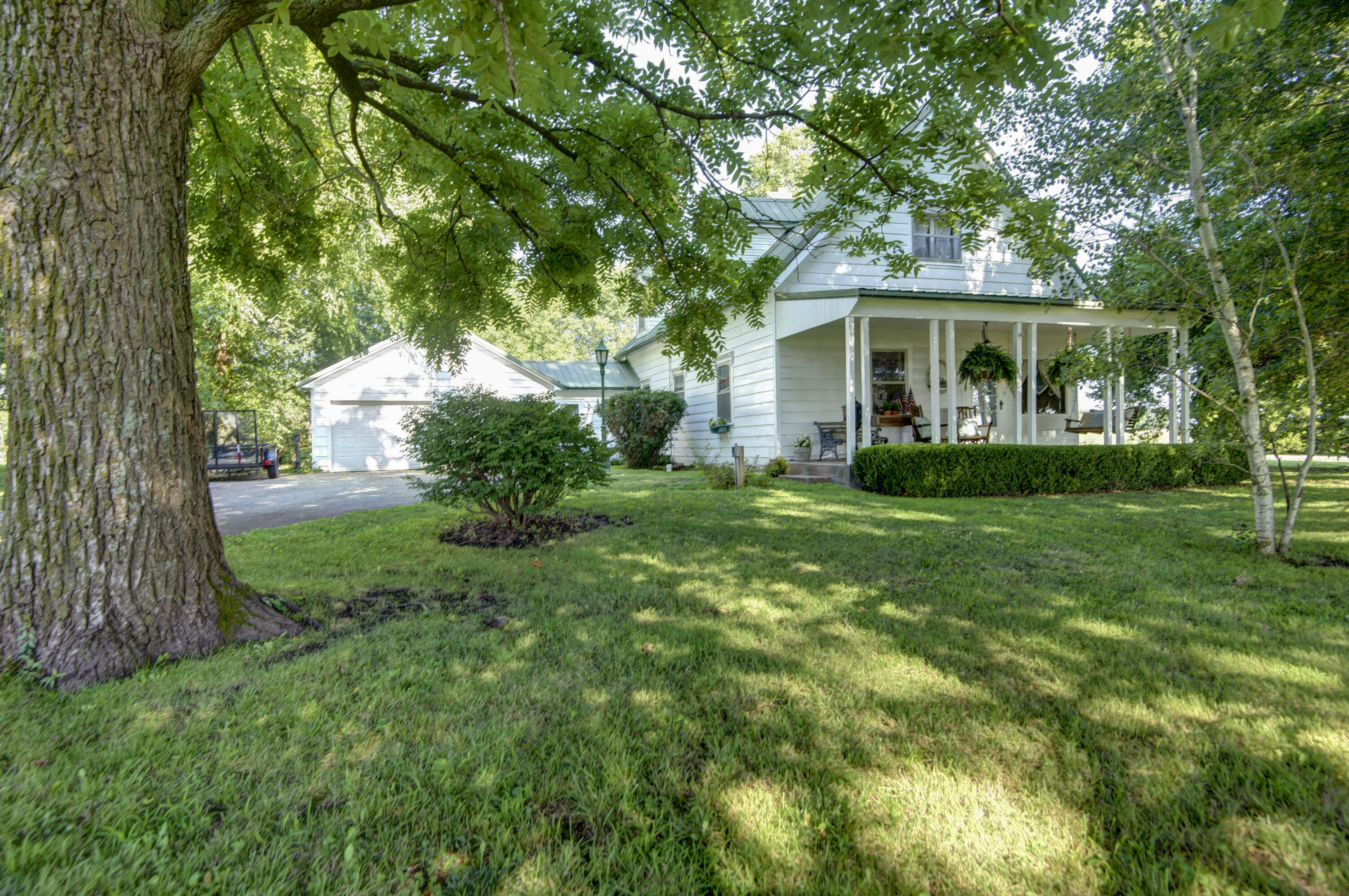 Nestled in the heart of the countryside, this enchanting farmhouse captures the essence of timeless beauty and rustic charm. After enjoying the serene surroundings from the front porch, step inside this beautiful home where every corner tells a story.  The spacious living room boasts a wood burning, brick fireplace, tall ceilings and a lot of natural light.  You will find 2 large bedrooms and bath on the main level with additional 2 bedrooms and bonus room upstairs. The  kitchen, with vintage cabinetry also shares space for a kitchen nook and addiontial wood burning fireplace. The formal dining room invites you to enjoy the simple pleasures of country living. Outside the possibilities are endless! Plant your vegetable garden, build a chicken coop, relax on the back patio and soak up the 9.4 acres with a pond and breathtaking views of the sunsets. Freshly painted exterior on home and garage! Newer 1,000 gallon Henson Concrete septic tank in 2017. A 500 gallon pump tank with filter was installed in 2019 and in 2020 the heating and cooling was replaced with a warranty that transfers with the new buyer! For those of you seeking a taste of the simple life, this charming farmhouse offers a blend of history, comfort, and natural beauty.  Come visit today and make this house your home!