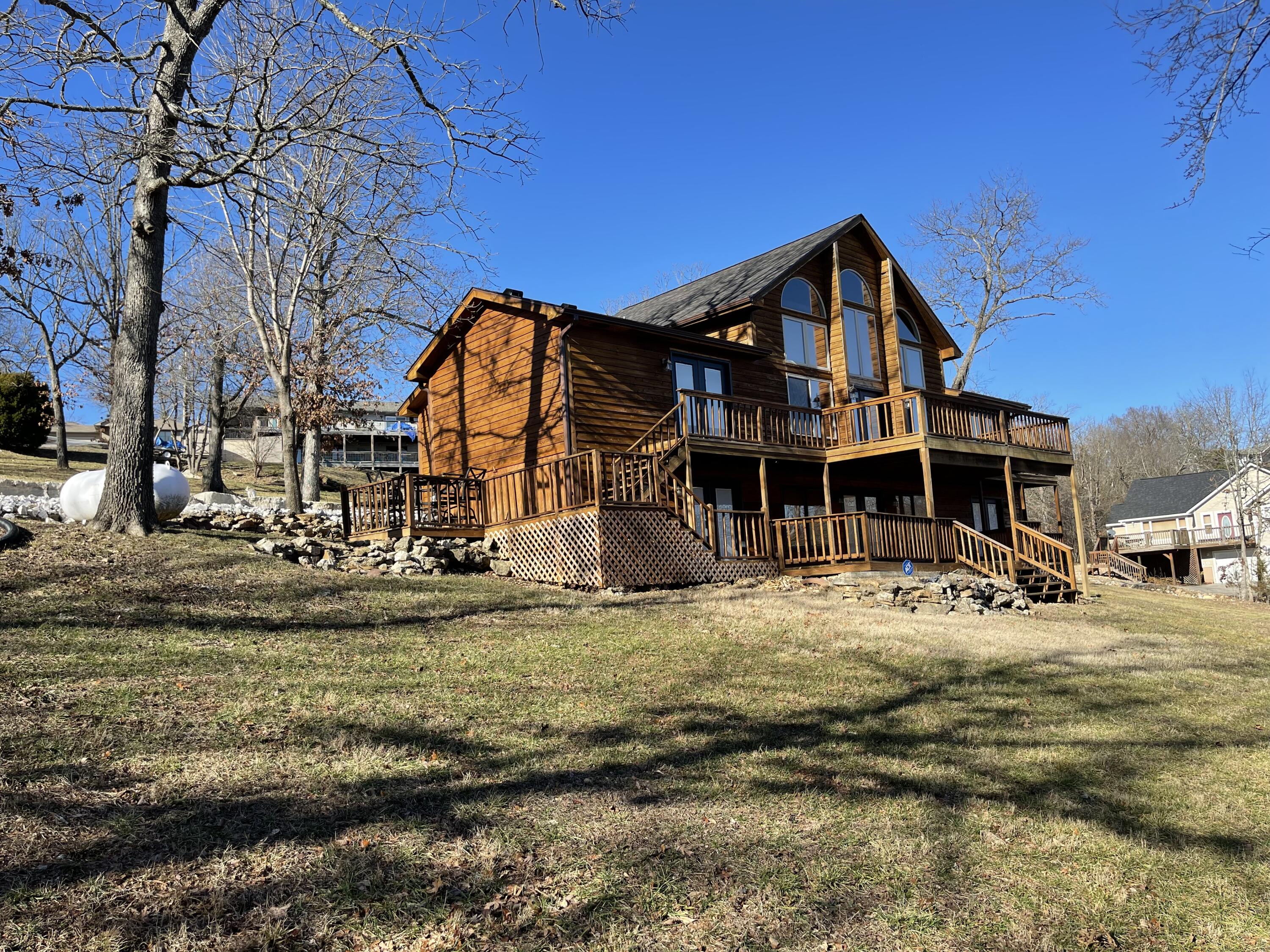 Lakefront home cleared to the water & plenty of elbow room! You just can't find a property that is gentle to the water with 200' of shoreline in such a great location with such an ''Up close and personal'' Lakeview of the Kimberling City Bridge!  Must see! This home is extremely Lakefront. The home sits on Lot 8 and the seller acquired adjoining Lakefront Lot 9 for newly built meandering concrete driveway. The 14x40 boat slip is located one lot over behind the dock parking (additional $75k). This is a very unique property that has been a work in progress with each lot purchased separately. To be sold furnished.  The Seller took the opportunity to start acquiring and creating a hard-to-find property that you must see how easily you can take to the next level! All components needed have been acquired! The seller also acquired the lots 259 & 260 to the north of the house if someone wanted to build a separate shop w/separate entrance. (Lots 259 & 260 are not included in the price.) They can be purchased separately for addtitional $$. This Home has five dedicated bedrooms, three with queen beds, one with king bed, one with full bed and two daybeds with trundle units in the loft. Sleeps 17 comfortably. If you are looking for a gentle slope to the water, this is a hard-to-find lakefront property in a quiet neighborhood! New roof and gutters, new concrete driveway, new garage door, new exterior stain, and new French doors all in 2022. After purchasing the adjoining lakefront lot there was a retaining wall & an 18''x150' storm water diversion pipe installed in 2021.