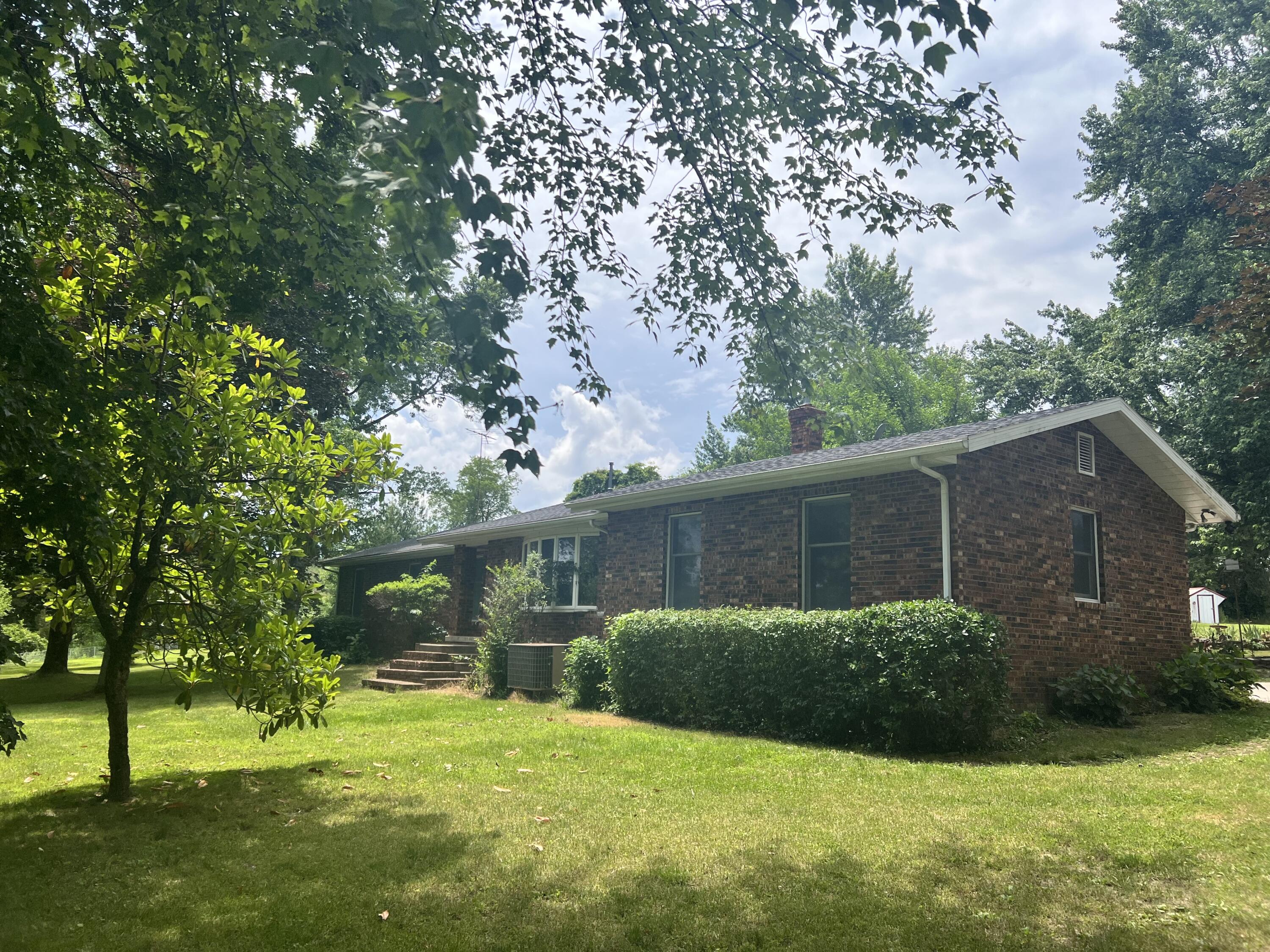 Southern Missouri Farmette For Sale! Come check out this hidden oasis just on the edge of town, featuring a 2 stall horse barn with tack room, additional 40x60 barn, open livestock shed, chicken coop (can include your own starter flock of chickens!), greenhouse, established nectarine, peach & pear trees as well as blueberry bushes, raspberries & asparagus. There are multiple patio spaces to enjoy the beauty of the landscape surrounding the home as well as an inground pool, complete with covered sitting or grilling space! Inside you will find 4 bedrooms, 2 1/2 bathrooms, open kitchen with eat in dining as well as a formal dining room, family room with gas fireplace, and formal sitting room/office space with brick wood fireplace. Located just outside the city limits of Mountain Grove, Missouri this property has a gated entrance and is fenced around entire perimeter. Bring your livestock and your swimsuit...and jump into Ozarks living!